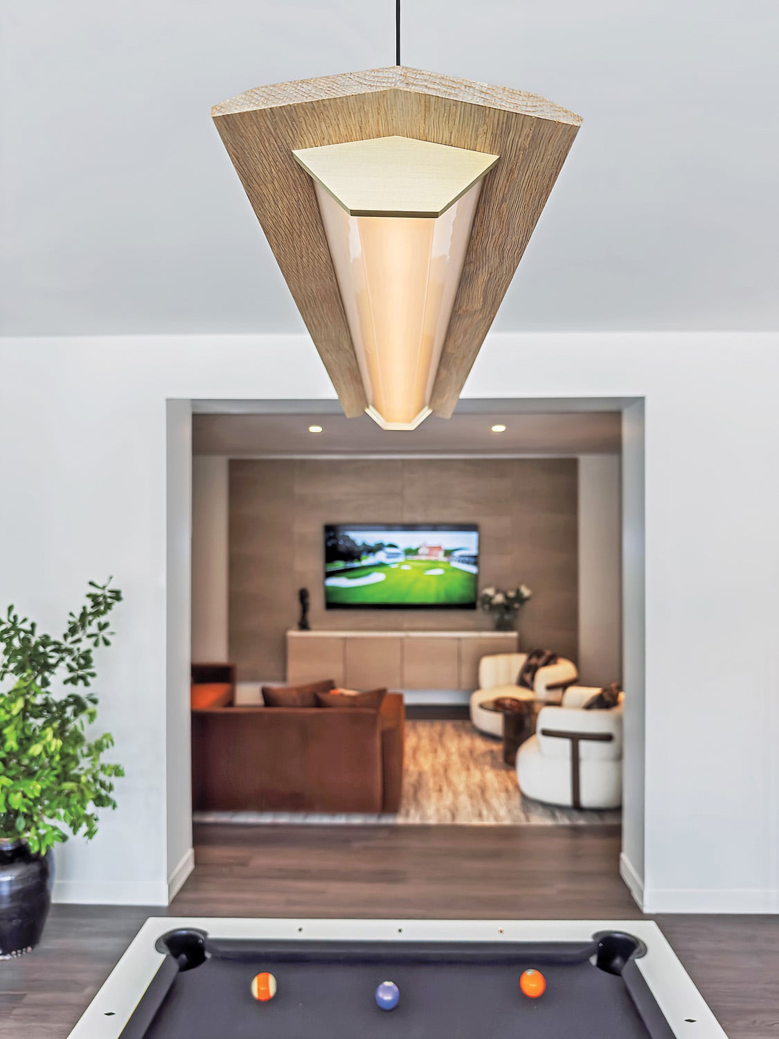 Sectional and swivel seating, flanking a bronze-glass side table, appoints the fourthfloor amenity suite’s media room.