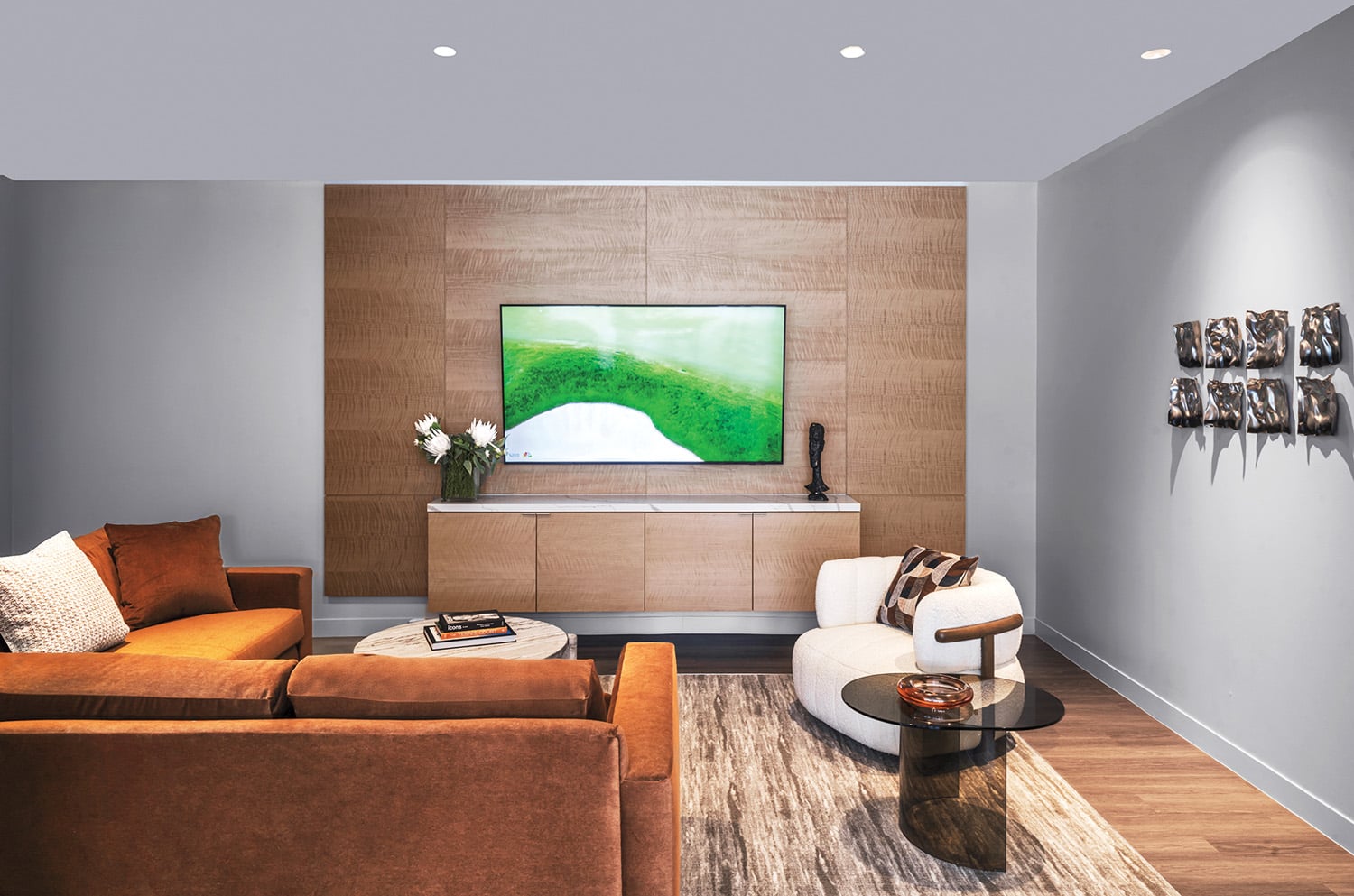 Sectional and swivel seating, flanking a bronze-glass side table, appoints the fourthfloor amenity suite’s media room.
