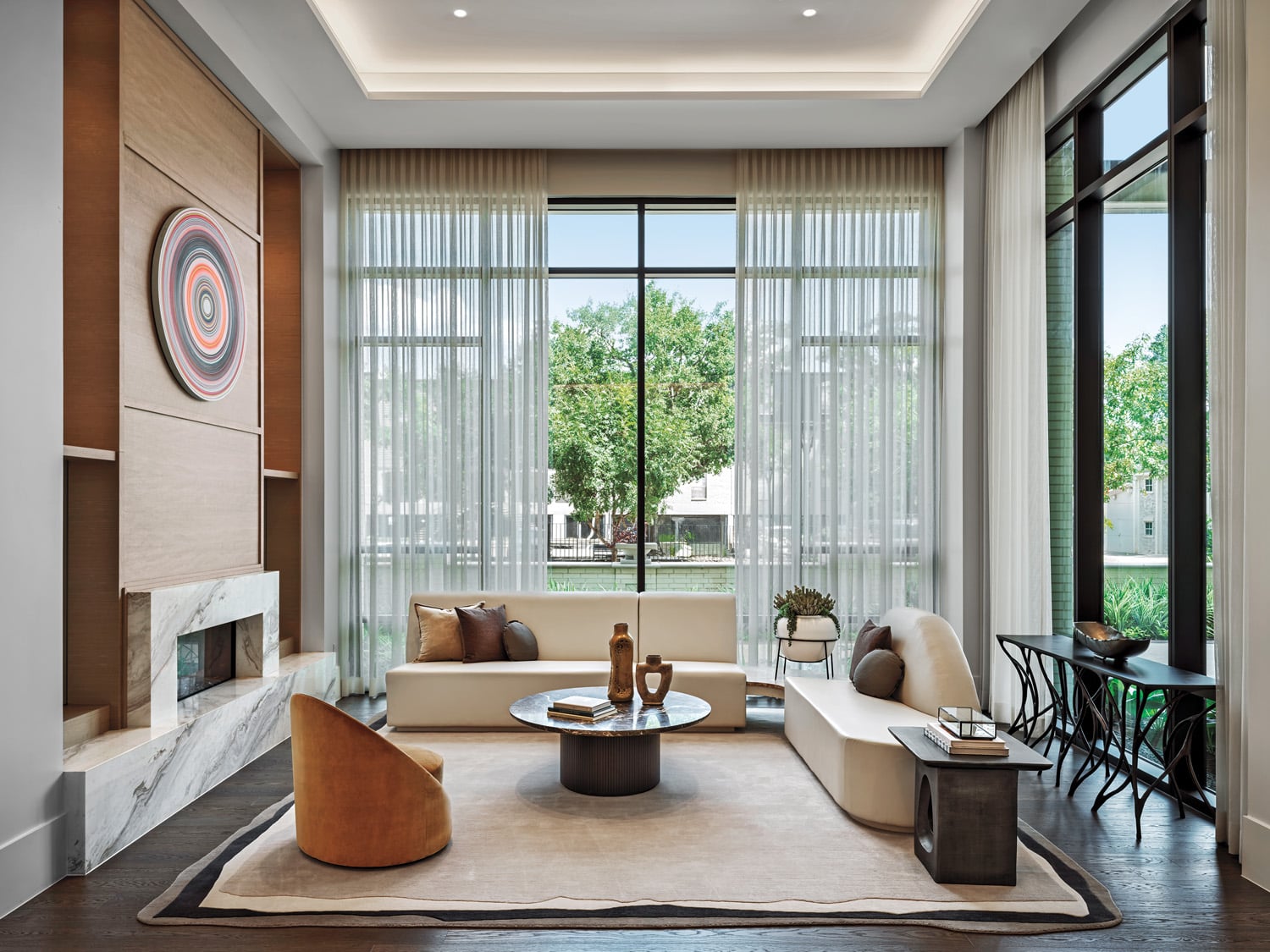 A double-sided fireplace bifurcates the lobby lounge furnished with custom sofas, Lauren Rottet’s Artis club chair, and Pilate, a David Hardaker painting. 