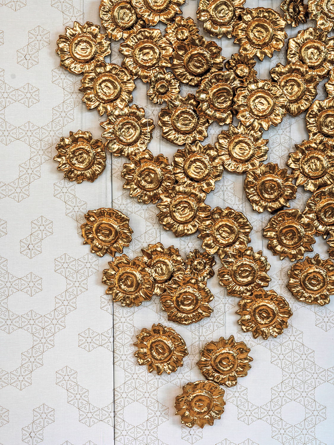 Joe Davidson’s cast-metal wall installation Golden Halo glitters in reception.