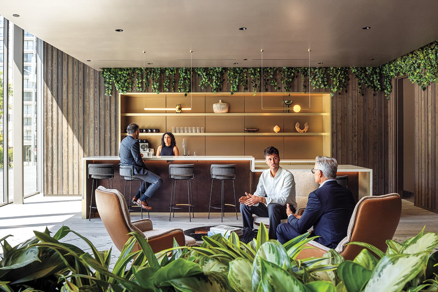 people sitting on bar stools near greenery