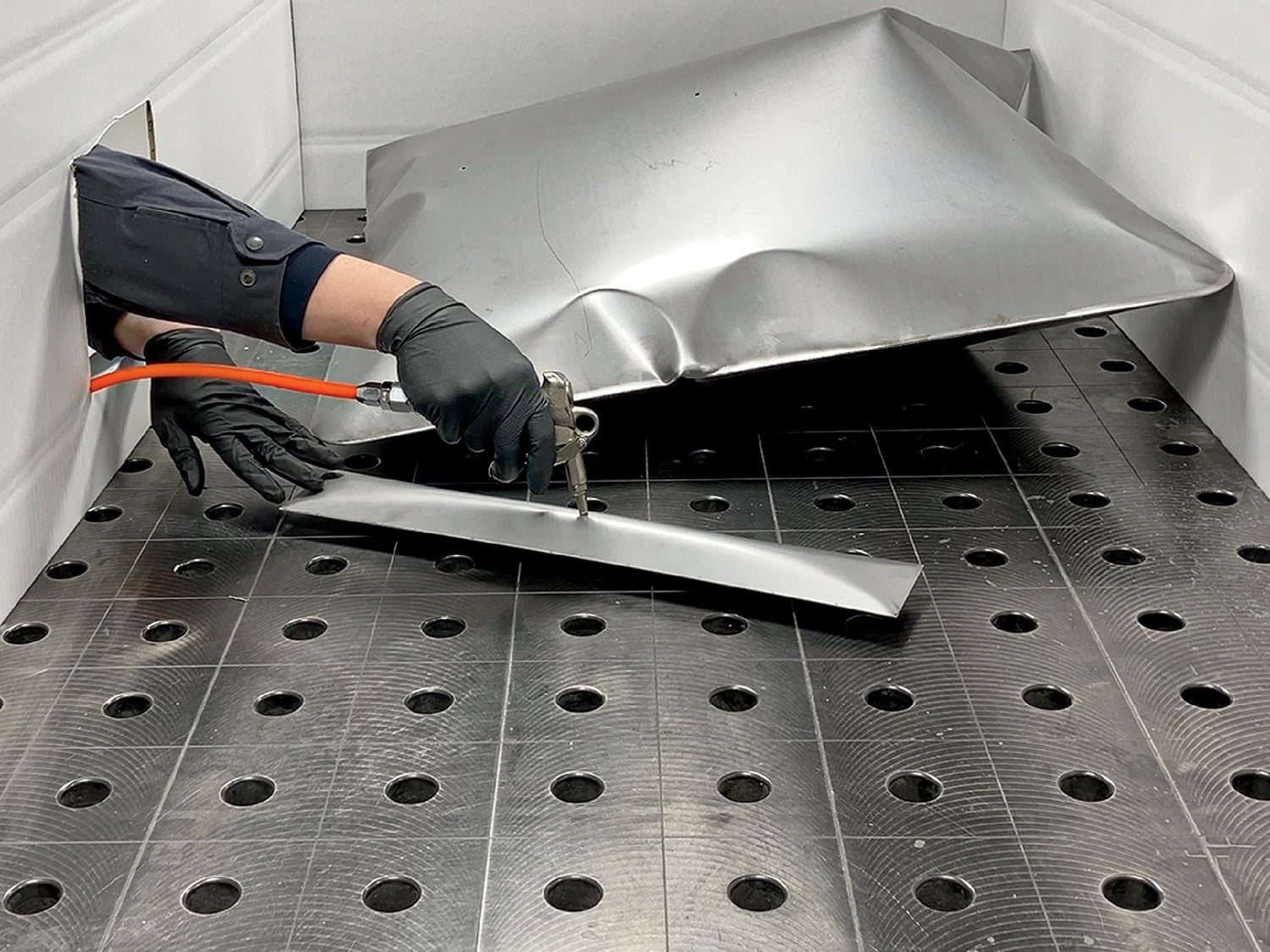 A man is installing a metal sheet in a room