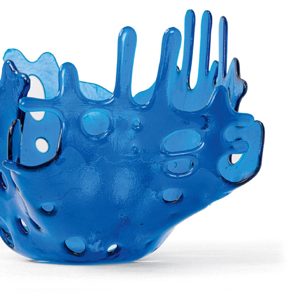 A blue sculpture of a hand with holes