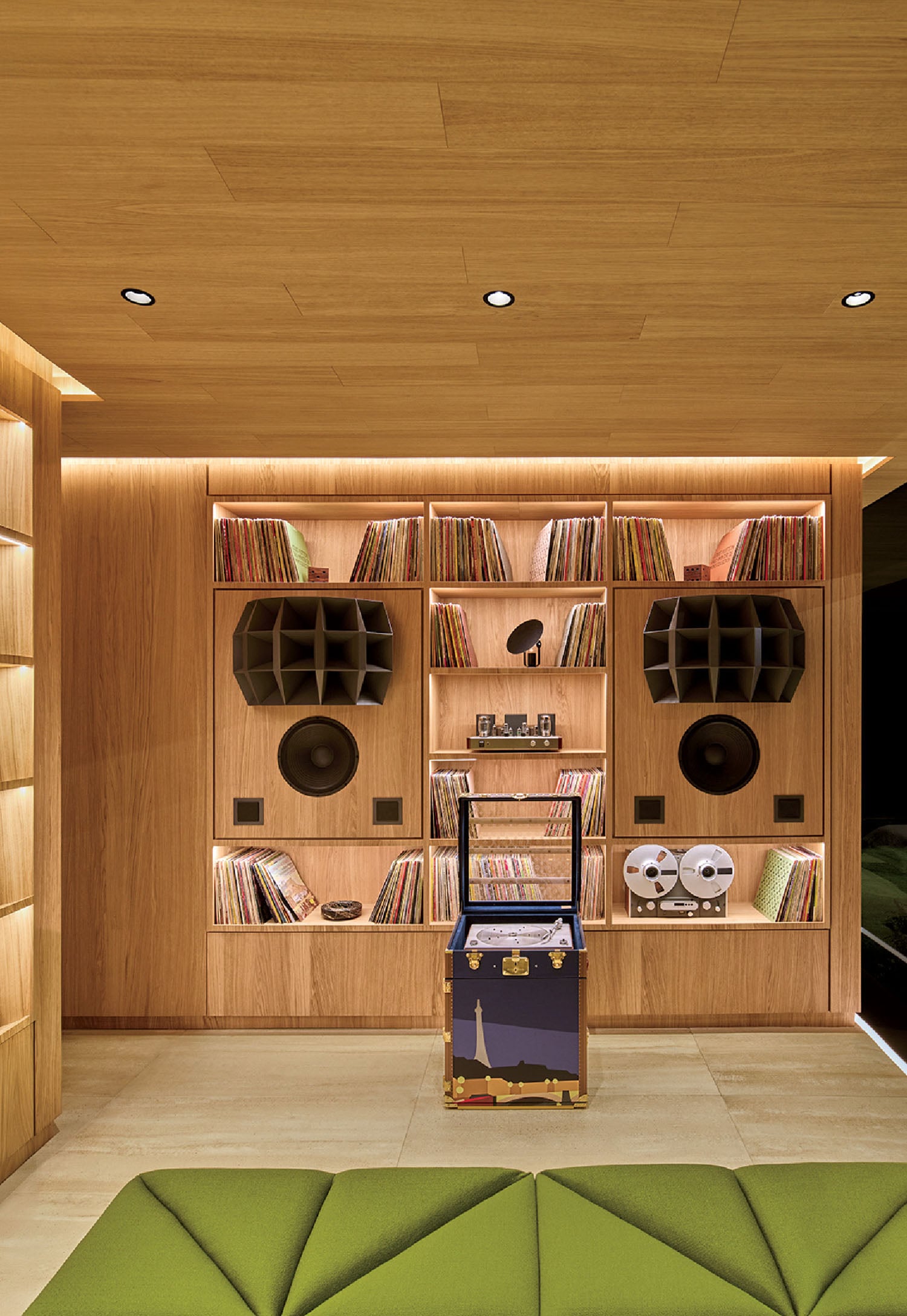 A room with a couch, bookshel, and a book shelf.