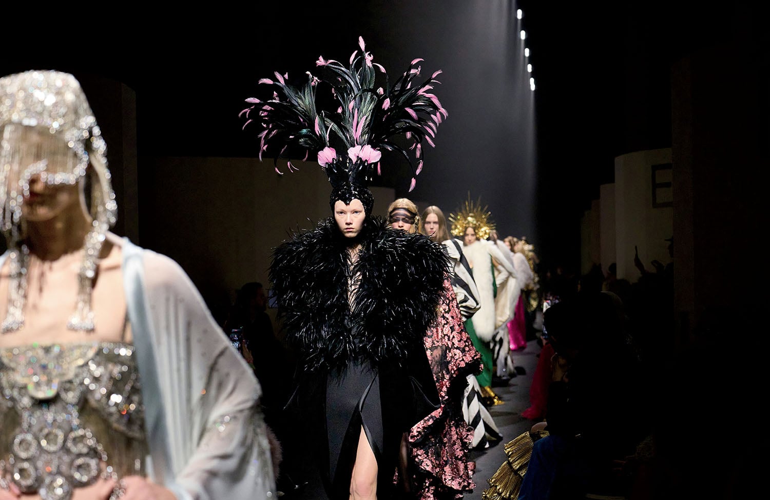 A woman in a black feather hat and dress.