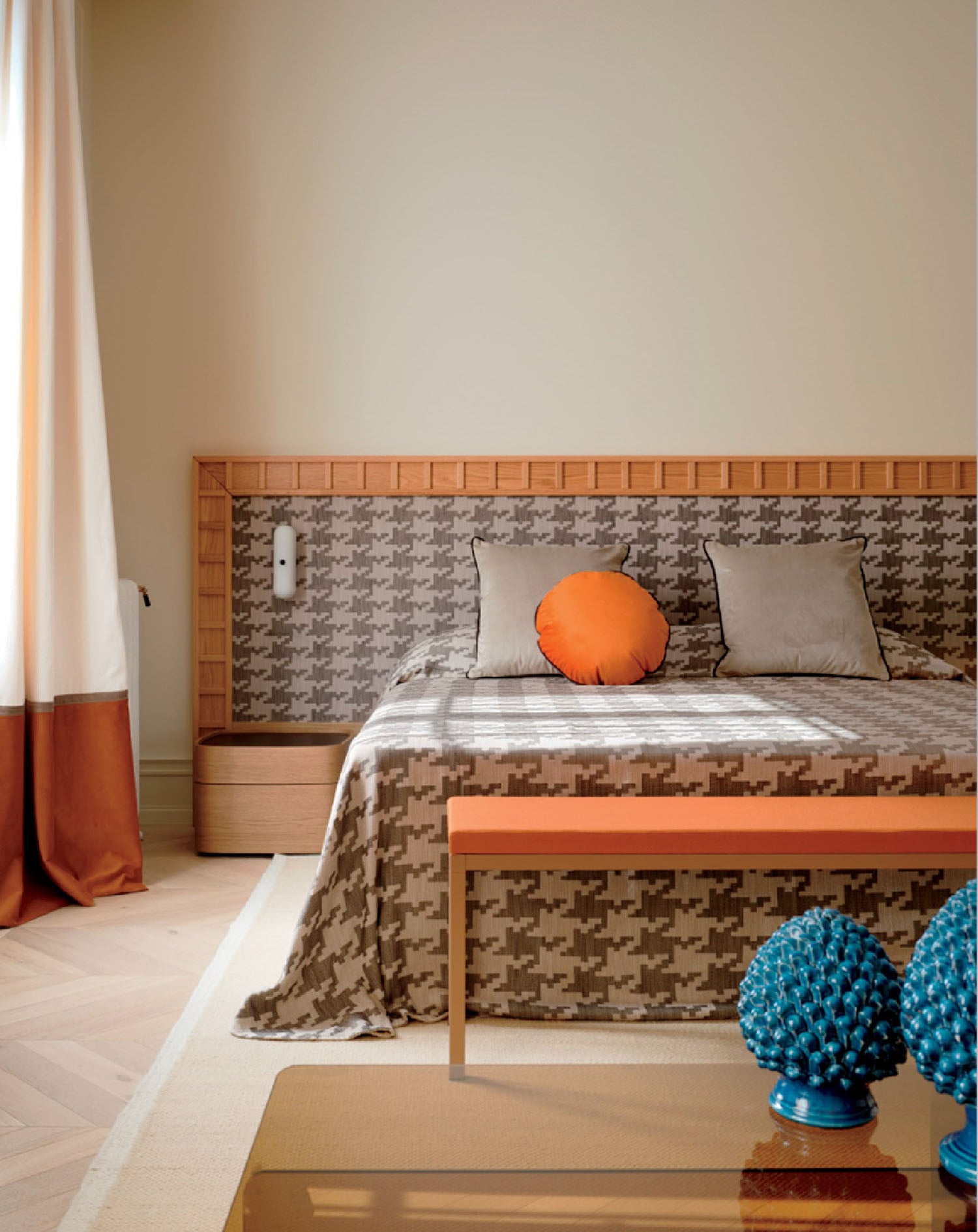 A bed with a wooden headboard and a blue vase.