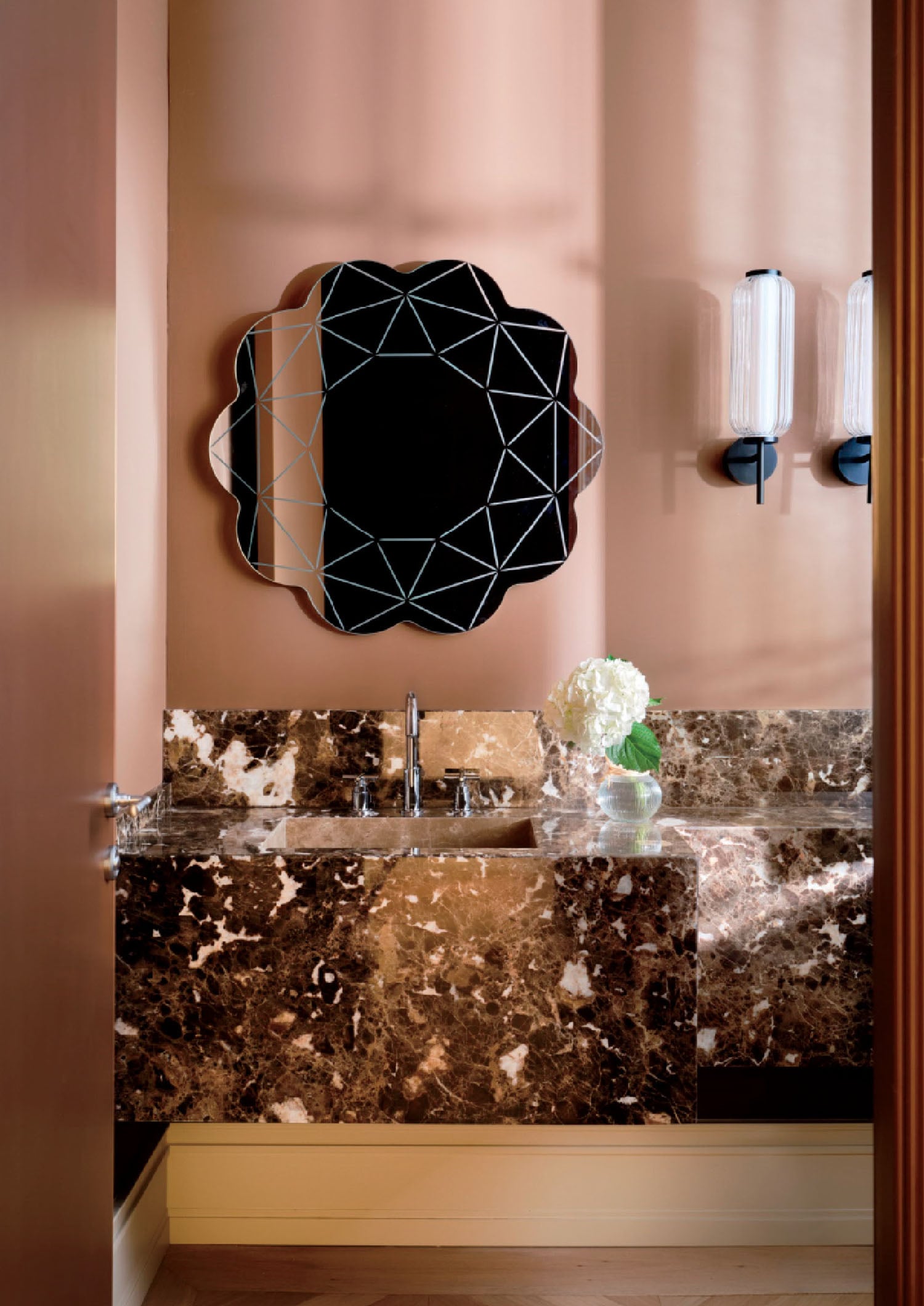 A bathroom with a marble sink and mirror.
