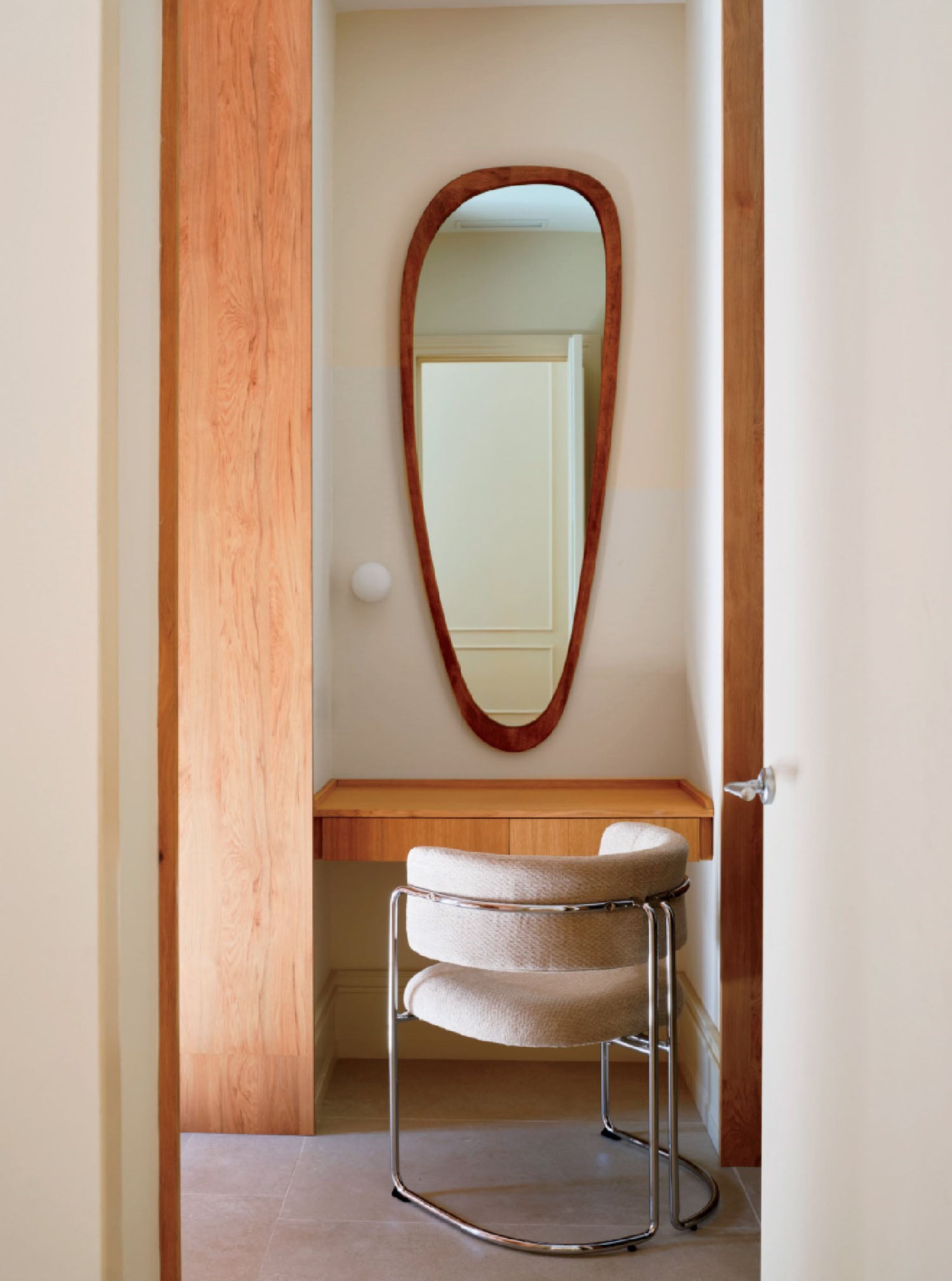A mirror and stool in a hallway.