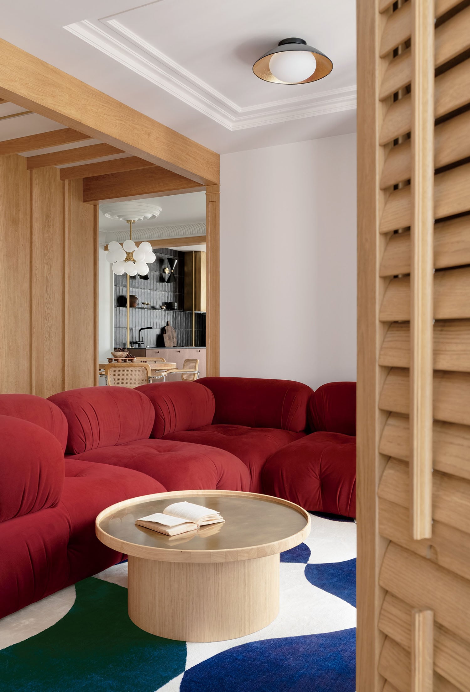 A living room with a red couch and a blue rug.