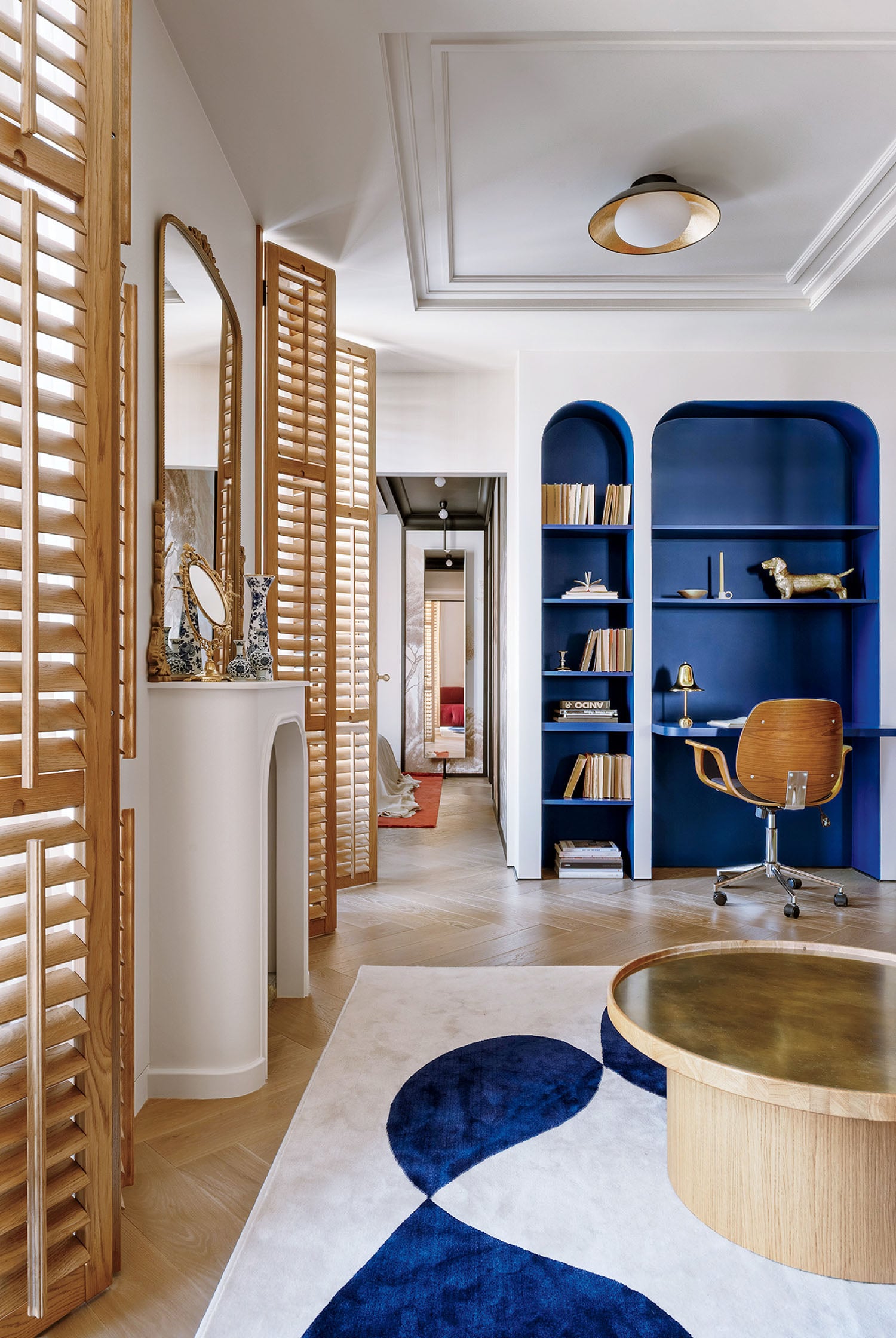 A living room with a blue wall and a wooden table.