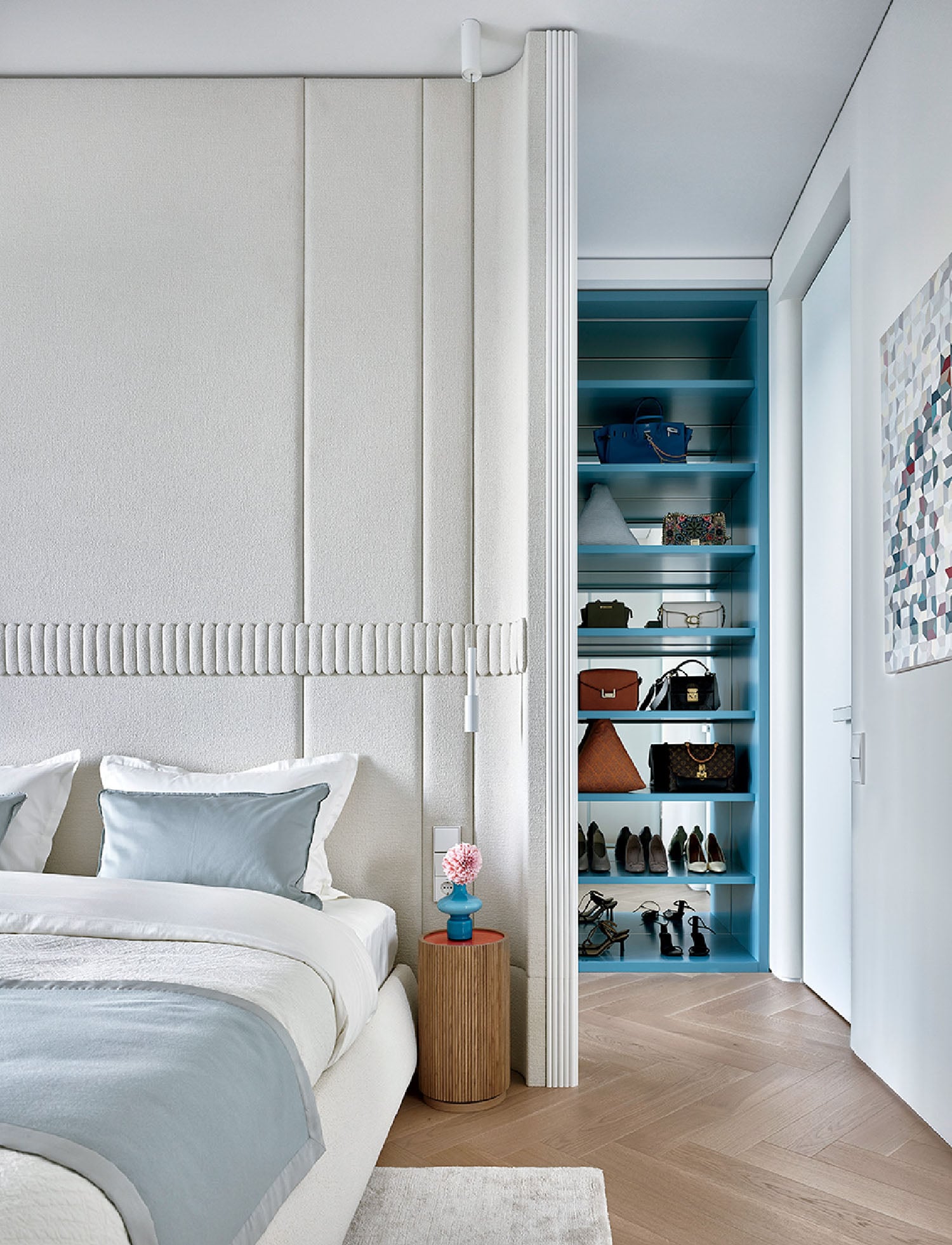 A bedroom with a bed and a blue bookcase.