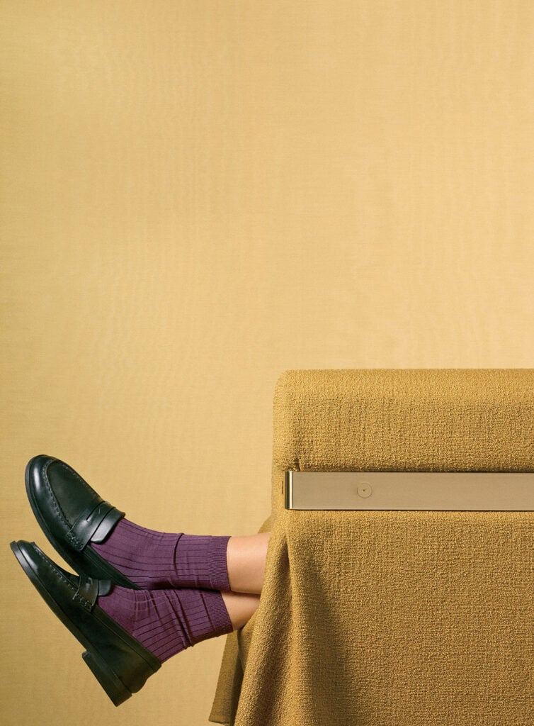A woman sitting on a couch with a laptop