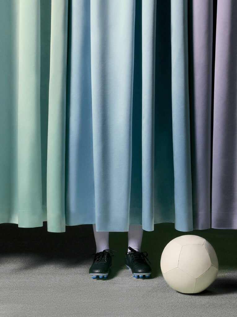 A soccer ball sitting in front of a curtain
