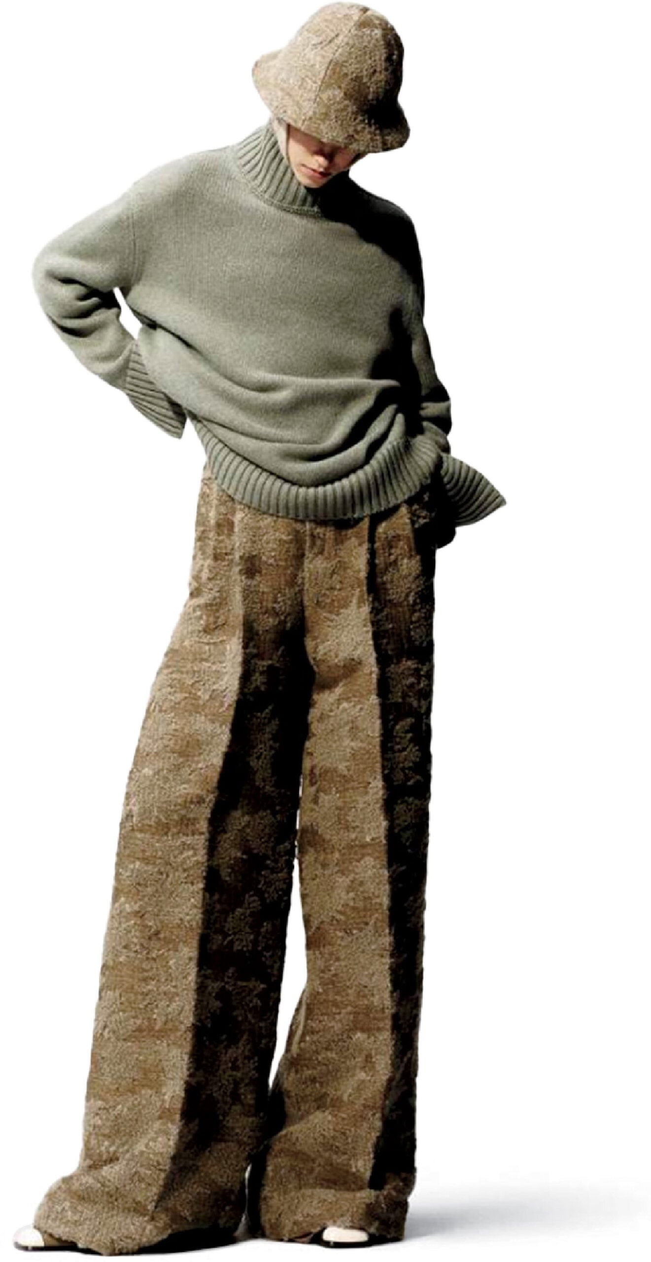 A man in a sweater and pants with a hat