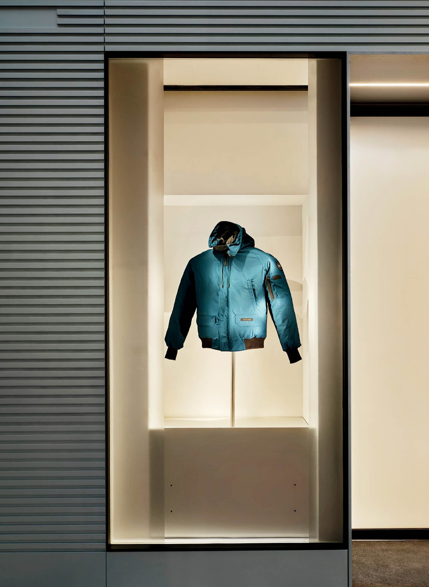 A blue jacket hanging in a window.