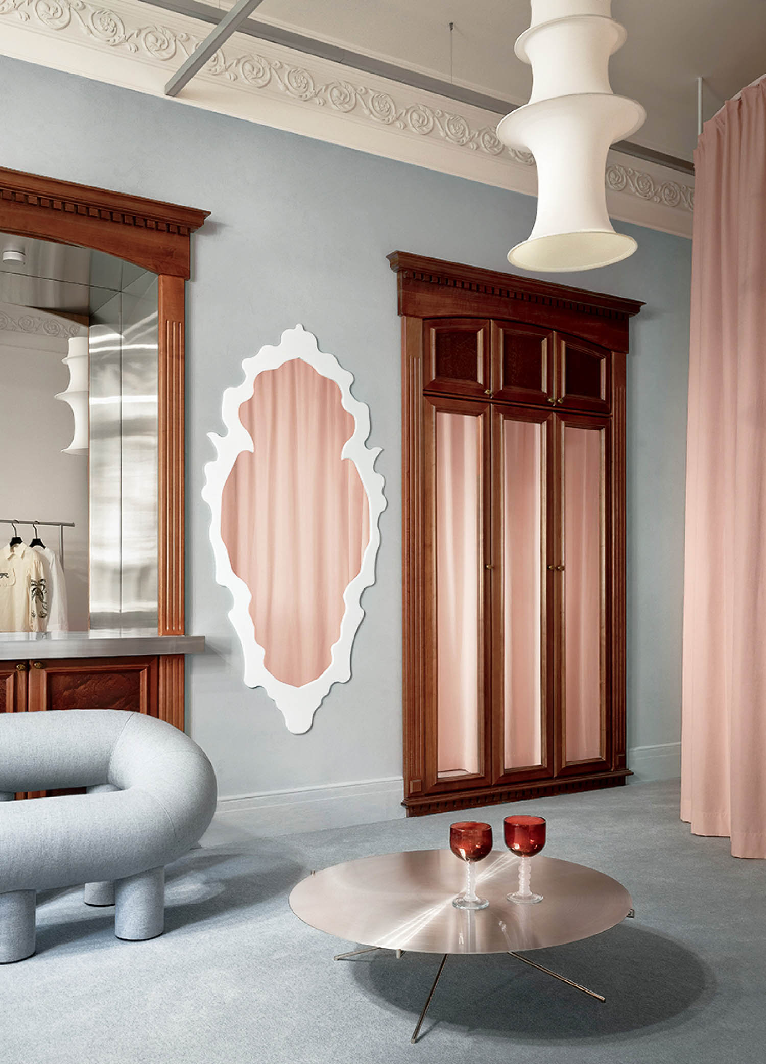 A room with a chair, mirror and a chair.