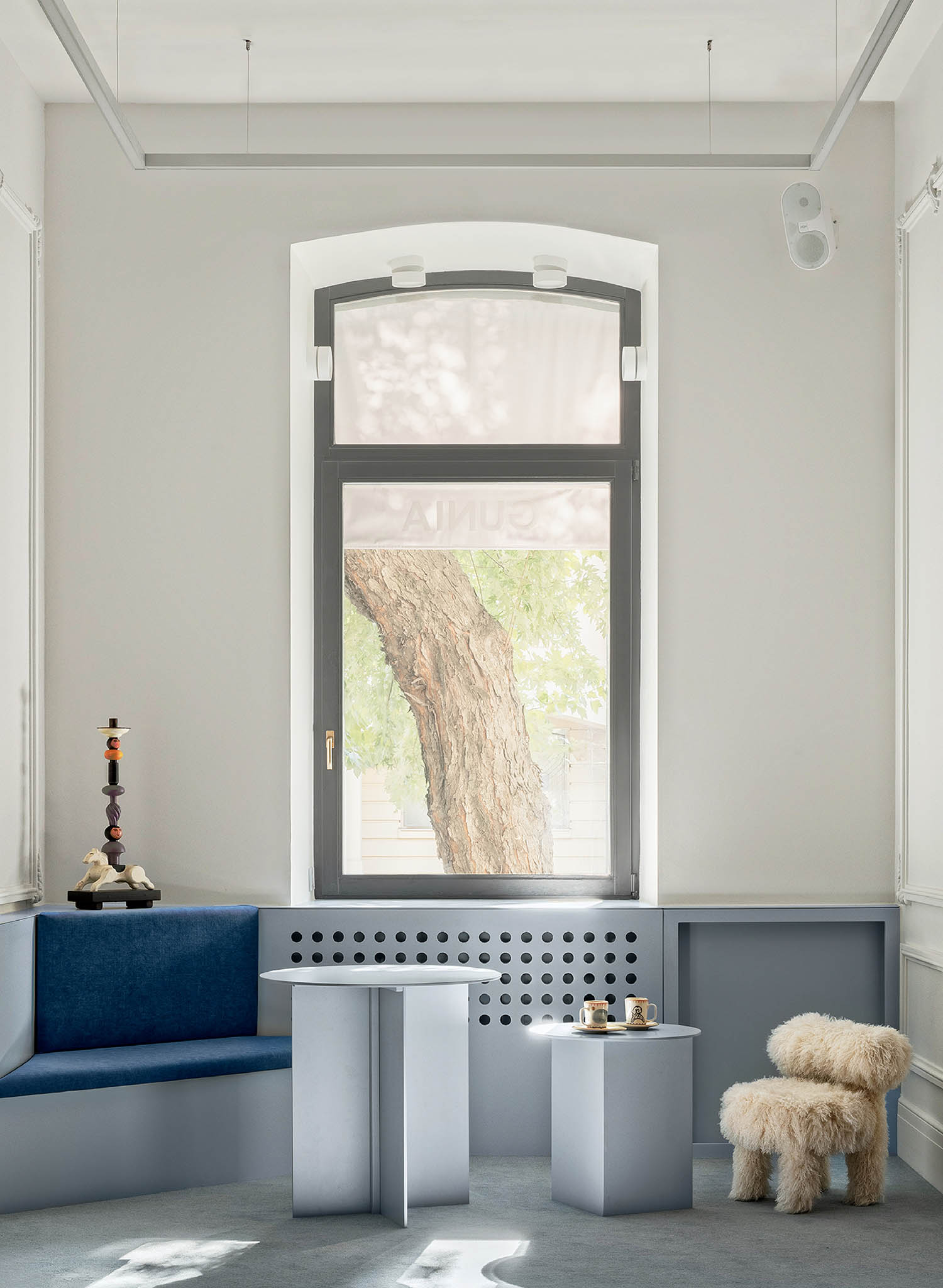 A blue bench and a white chair in a white room.