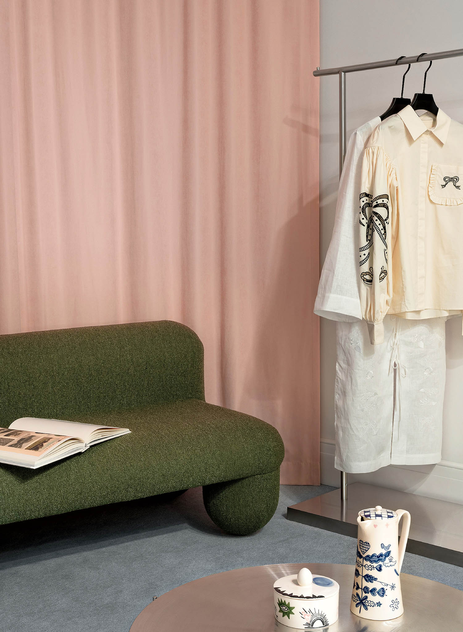 A green couch and a white shirt on a hanger.