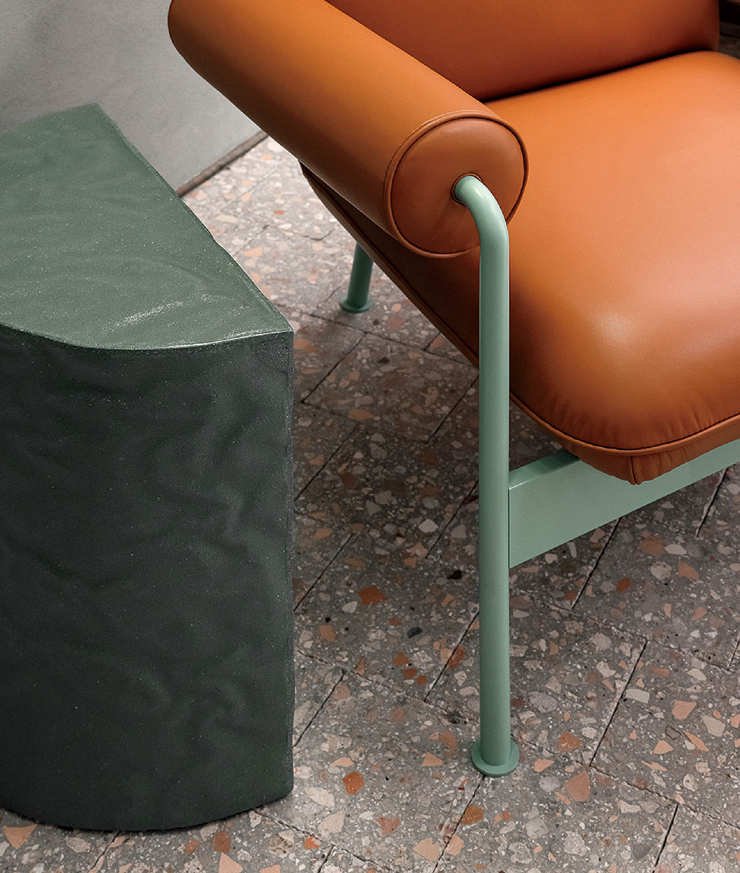 A chair and a stool on a sidewalk.