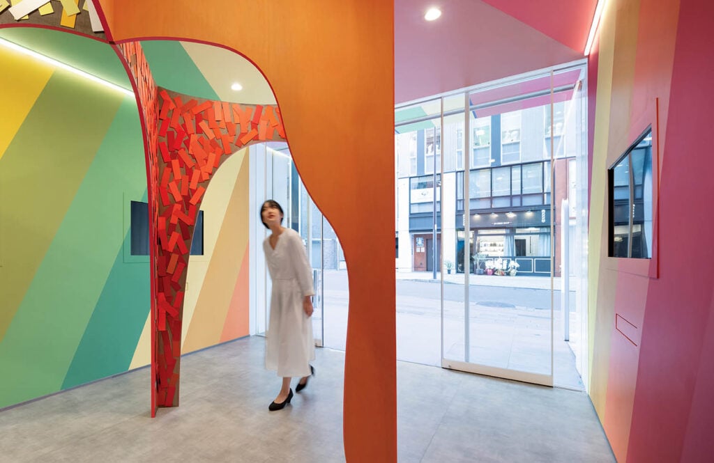 A woman walking through a colorfully painted office.