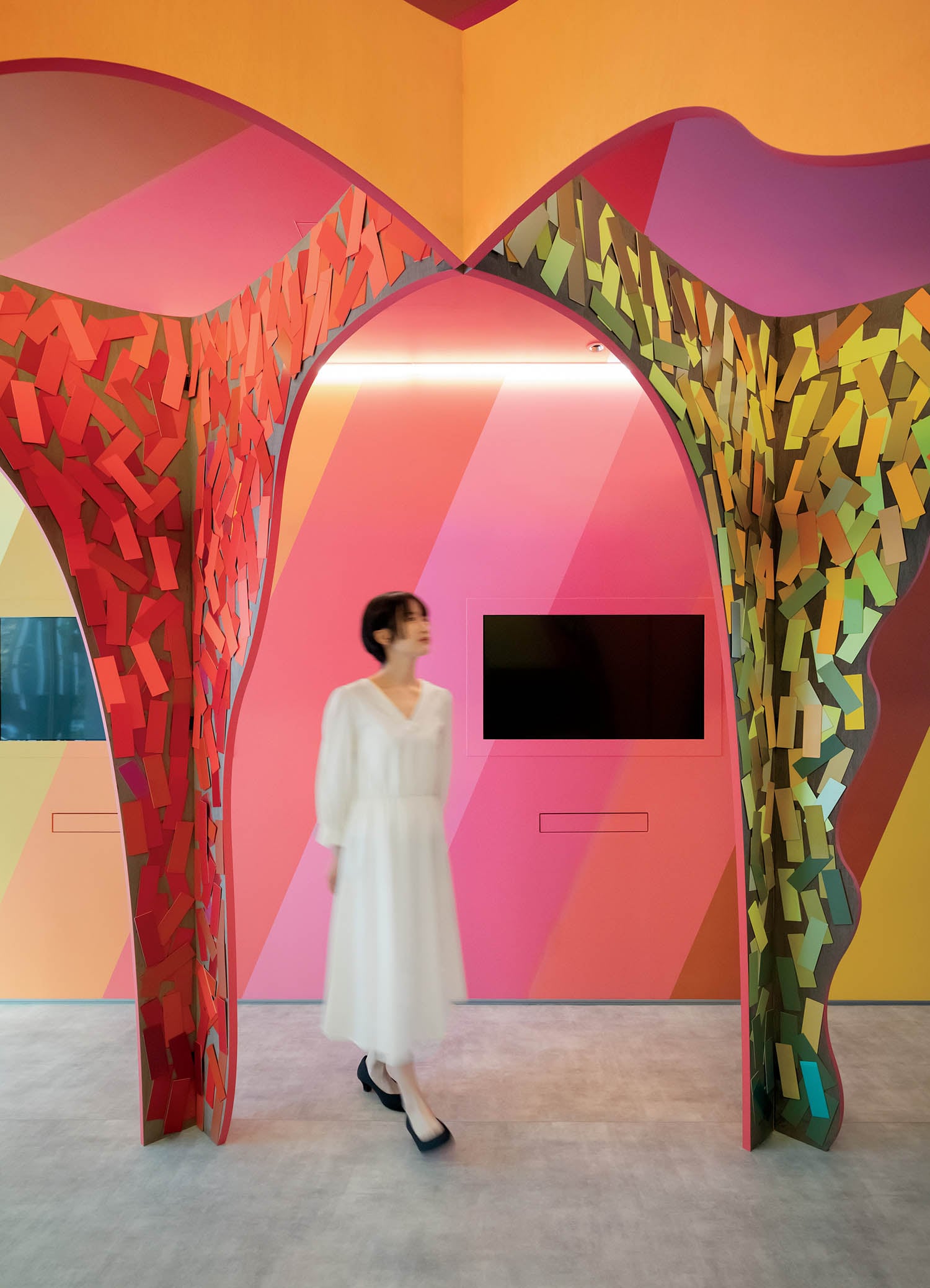 A woman walking through a colorful room.