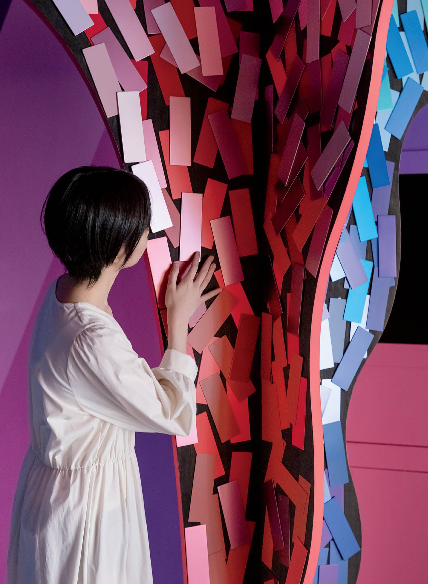 A woman standing in front of a colorful tree.