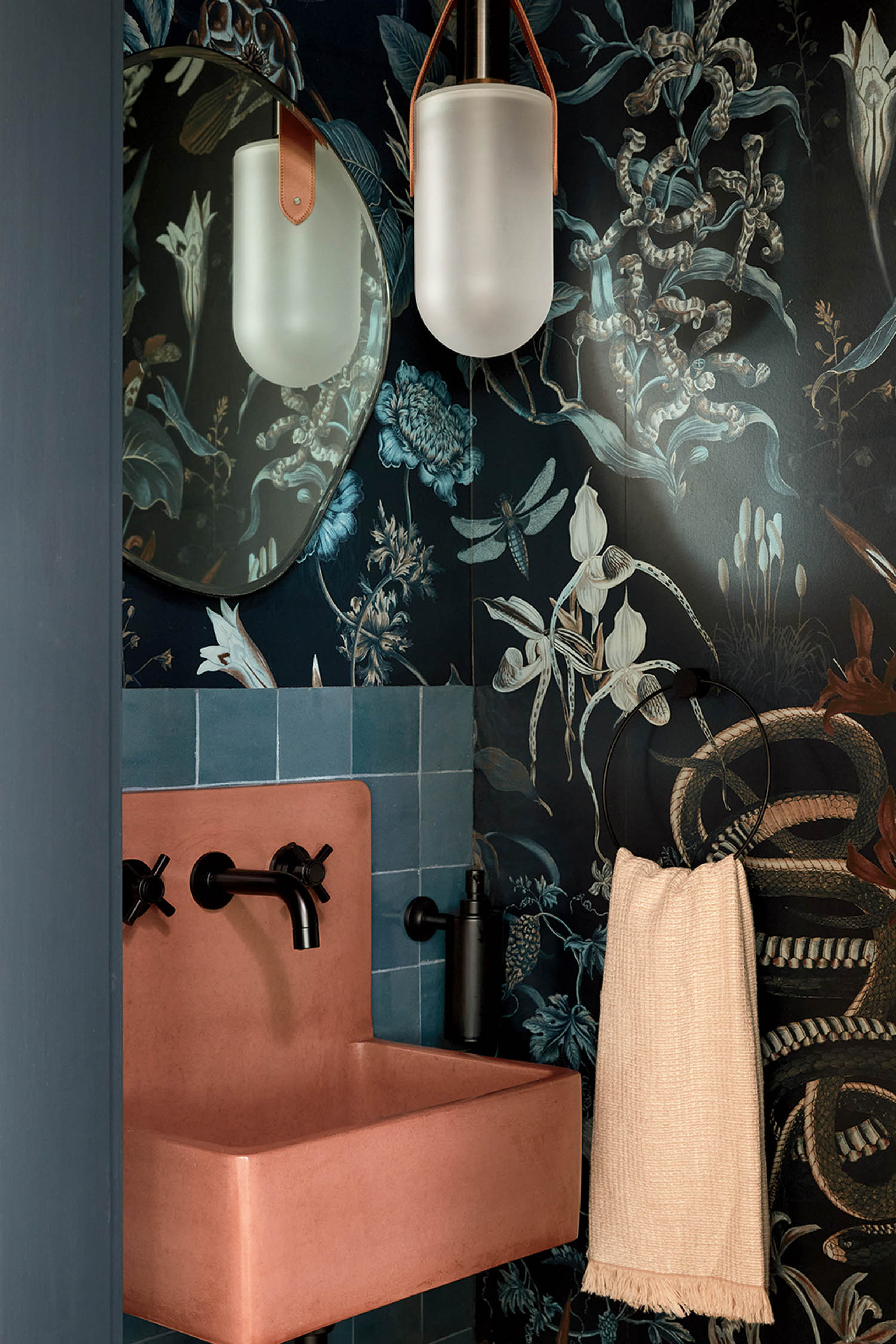 A bathroom with a sink and a wallpapered wall.