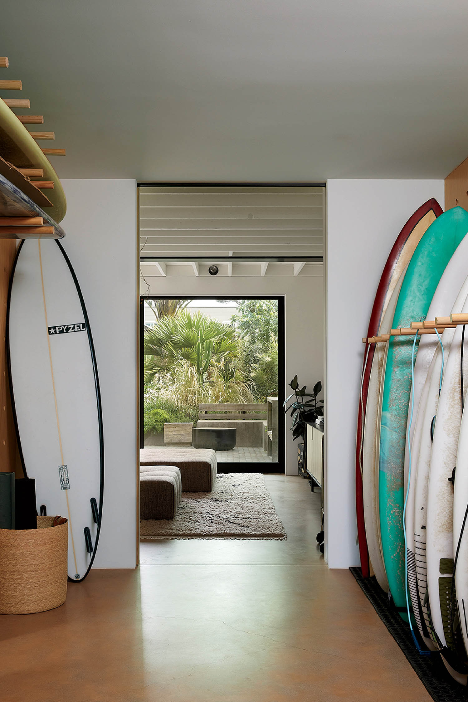 A room with surfboards and a surfboard rack.