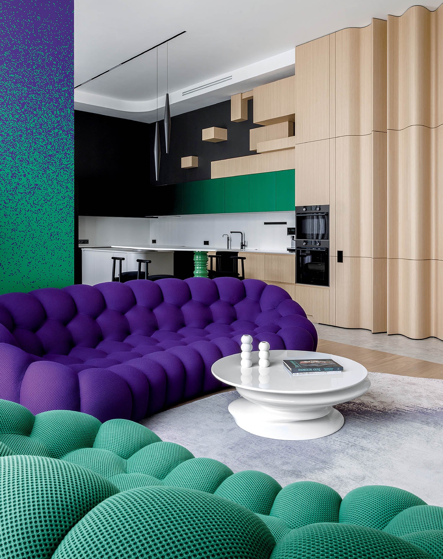 A living room with a purple couch and green pillows.