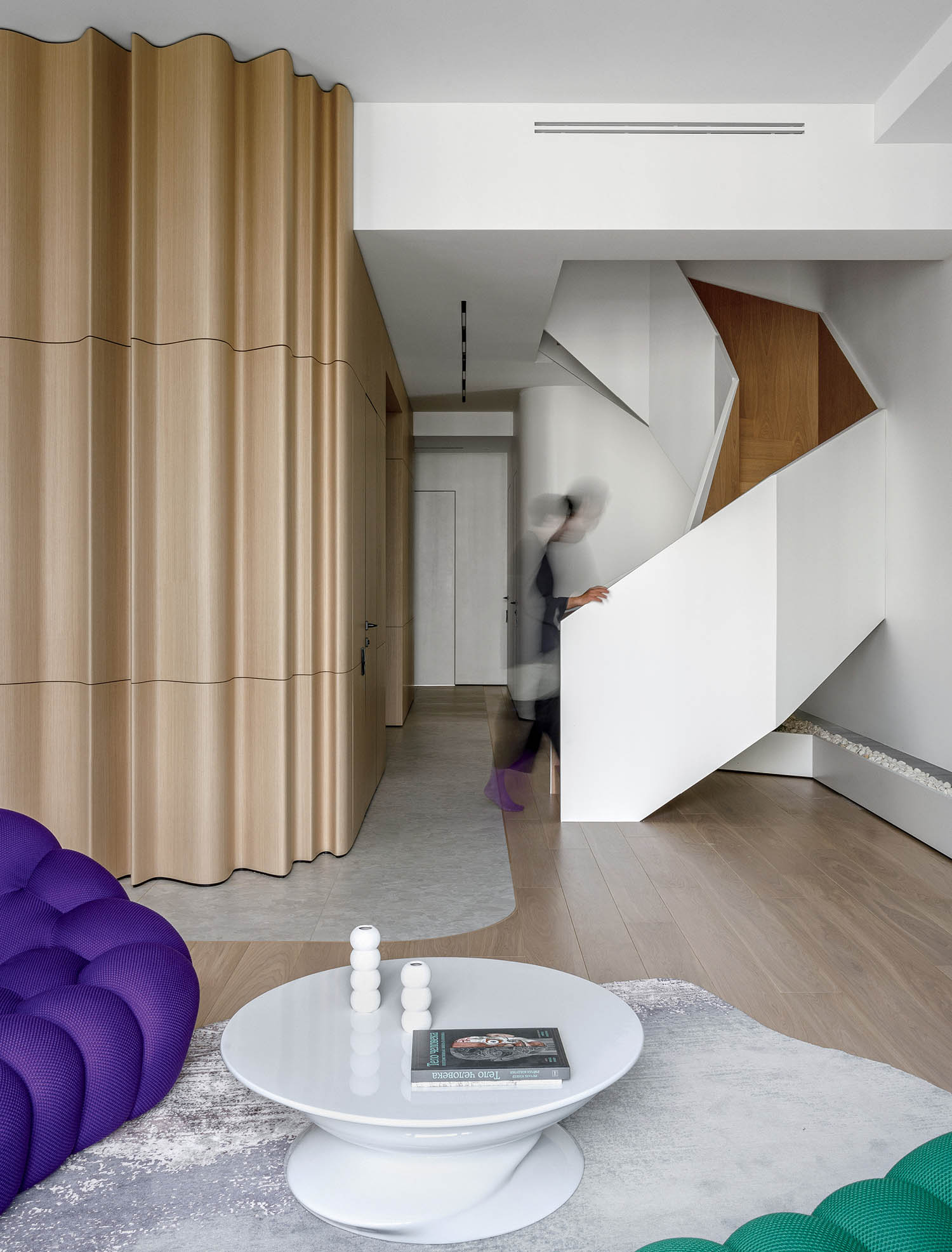 A living room with a purple couch and a white coffee table.