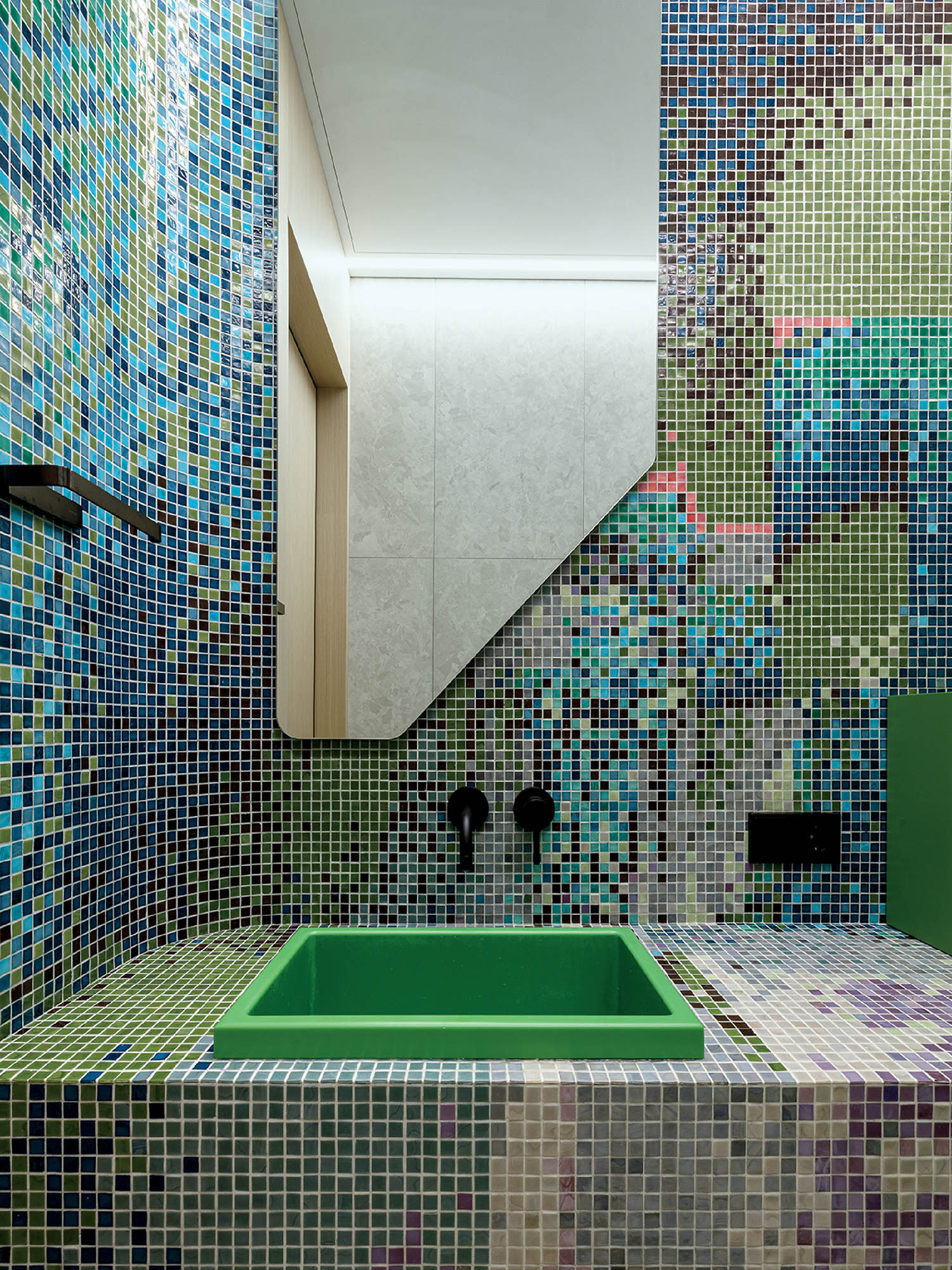 A bathroom with colorful tiles on the walls.