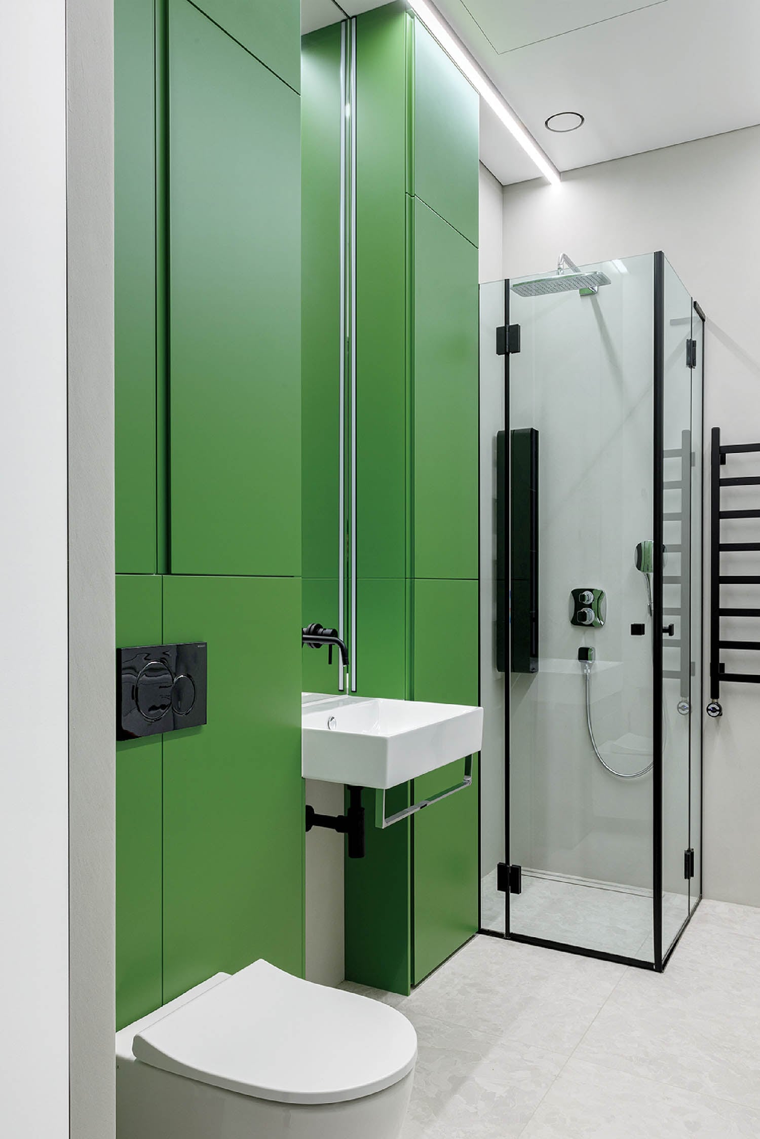 A bathroom with a green wall and a white toilet.