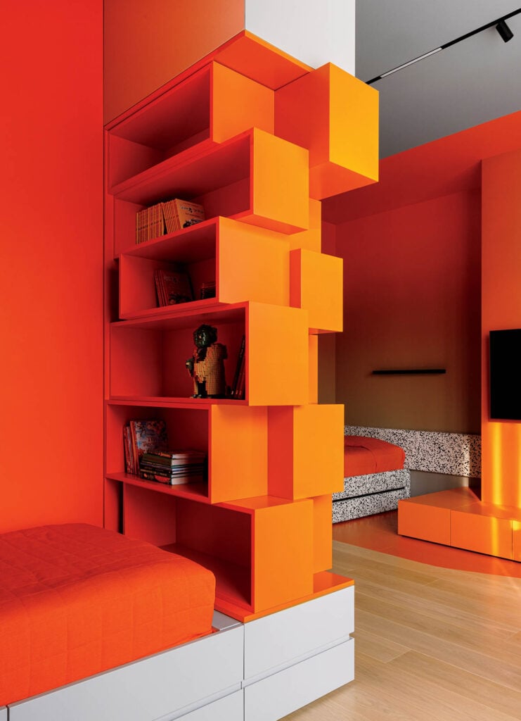 A room with a bed, a couch, and a book shelf.