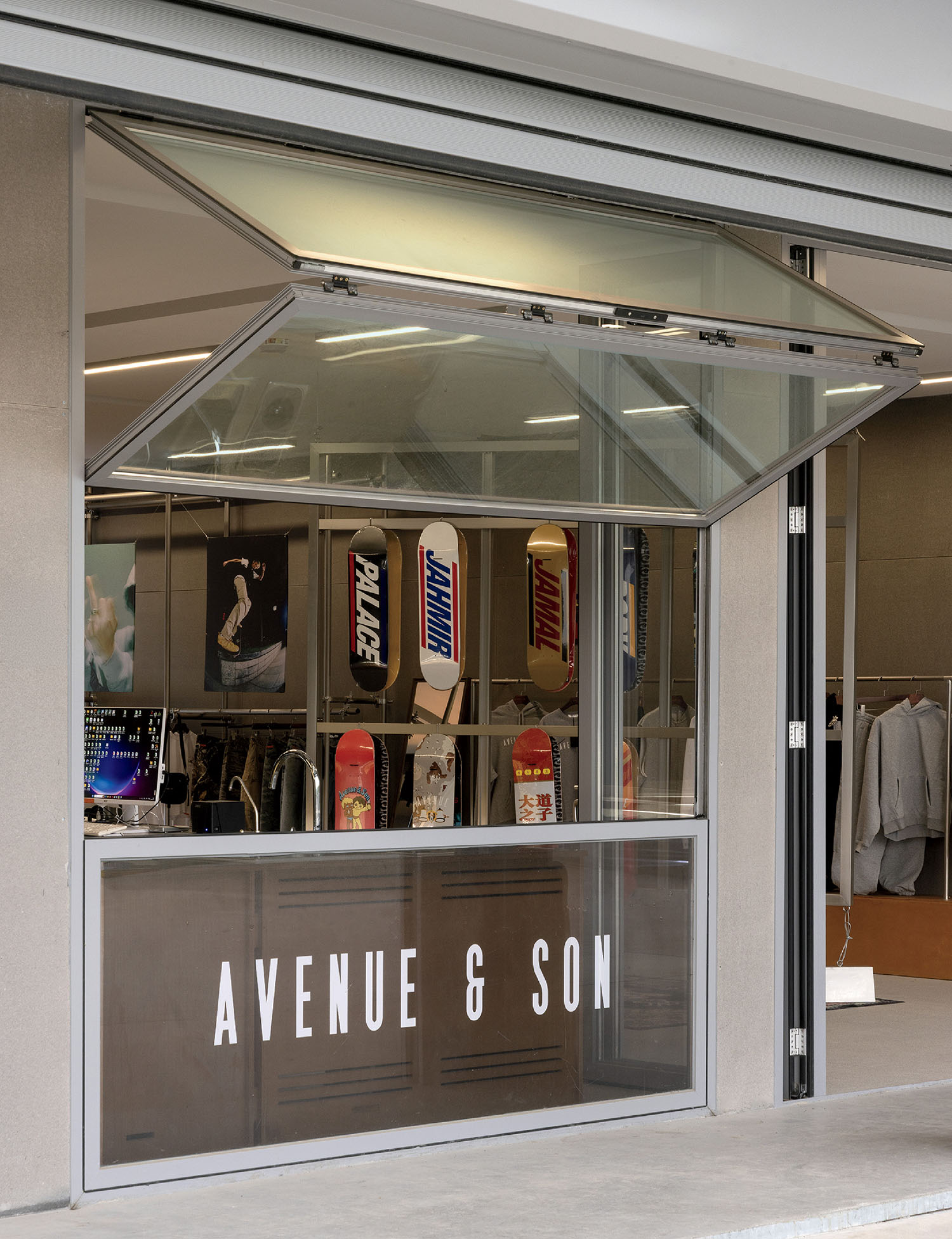 A storefront with a glass window labeled "AVENUE & SON" showing skateboards and clothing displayed inside.