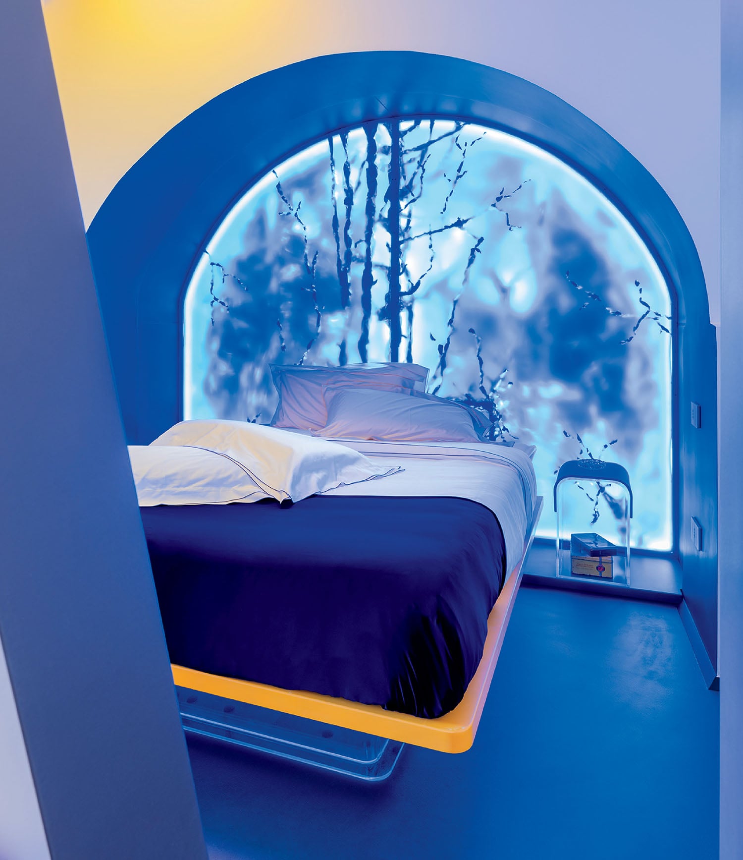 A modern bedroom with a floating bed, blue floor, and a large arched window featuring a nature-themed frosted glass design illuminated with blue light.