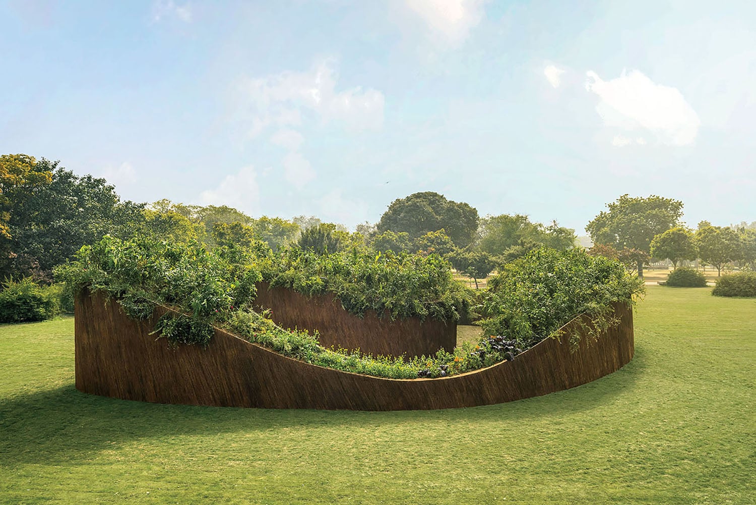 A curved, rust-colored metal planter filled with green plants sits on a grassy lawn, surrounded by trees under a partly cloudy sky.