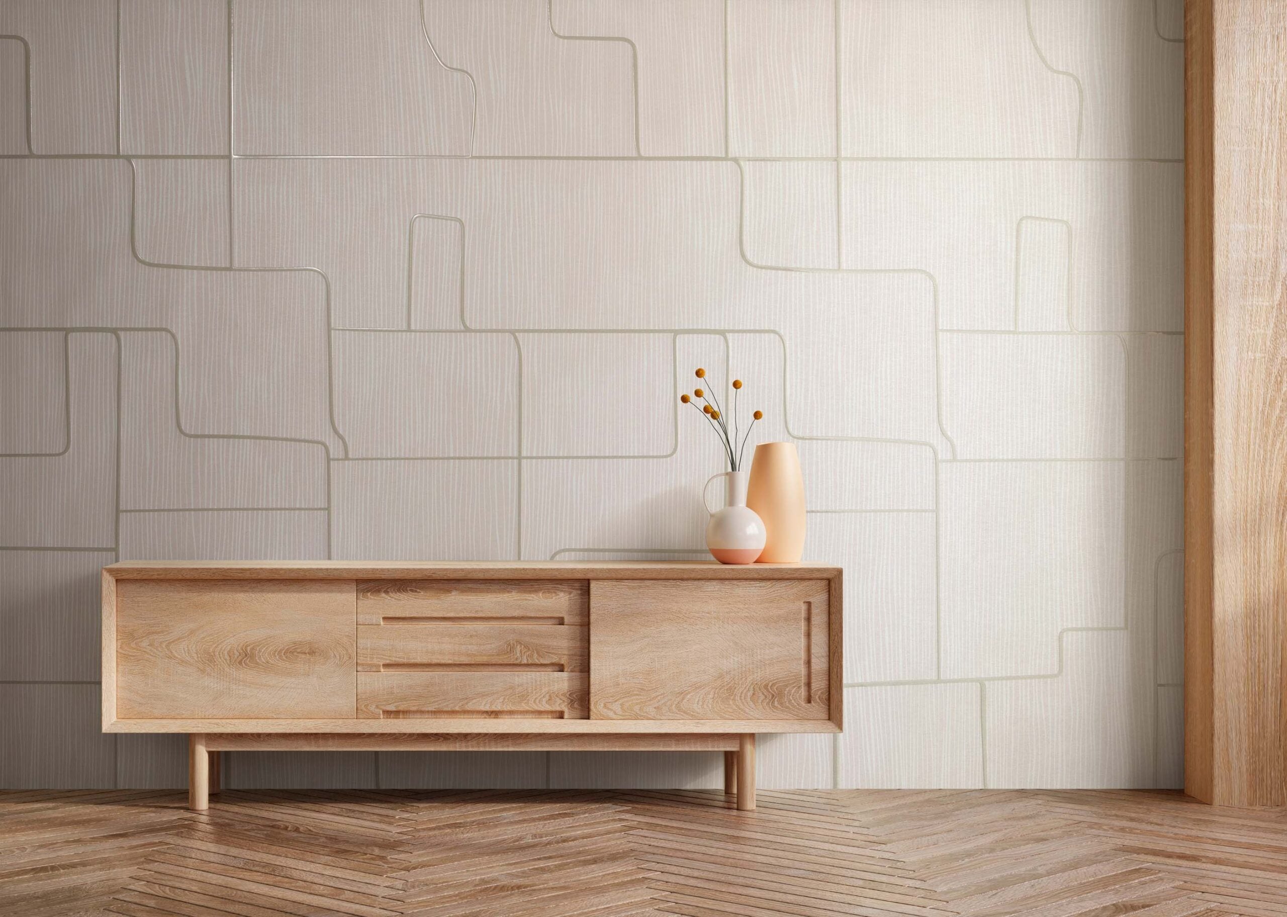 Minimalist room with a wooden sideboard, two vases with dried flowers on top, geometric light wood wall panels, and herringbone wood floor.