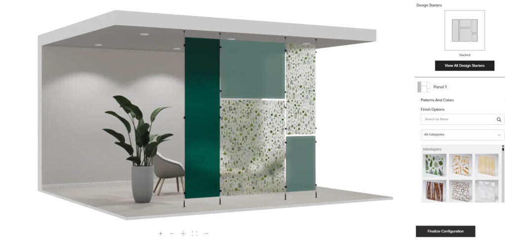 A modern room divider display with green, clear, and patterned glass panels, a gray chair, and a potted plant under a minimalist ceiling structure.