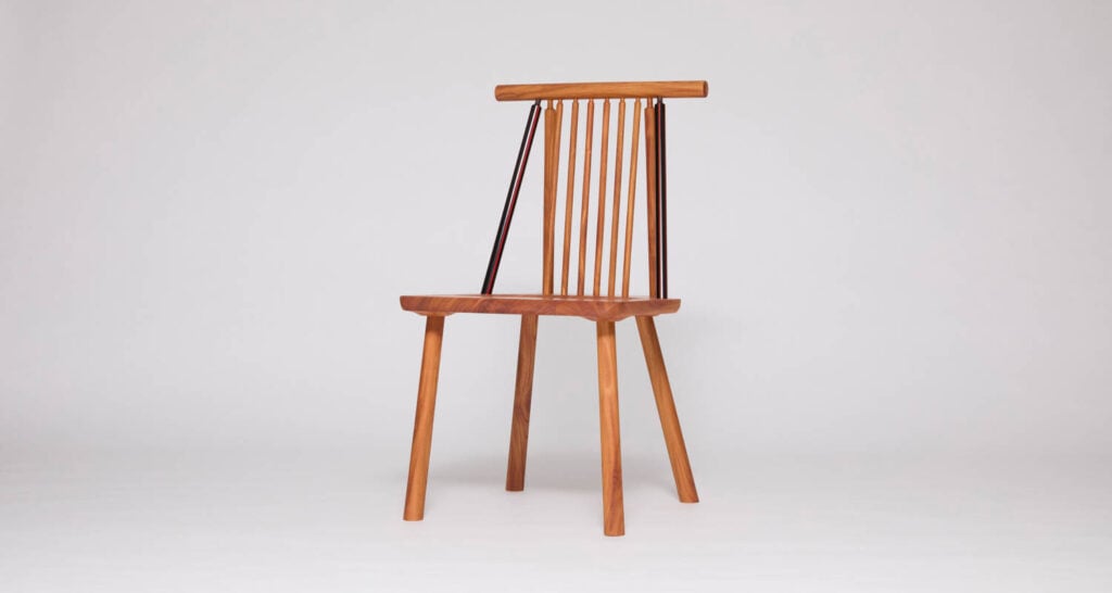 A wooden chair with a flat seat, four angled legs, and a vertical slatted backrest, photographed against a plain white background.