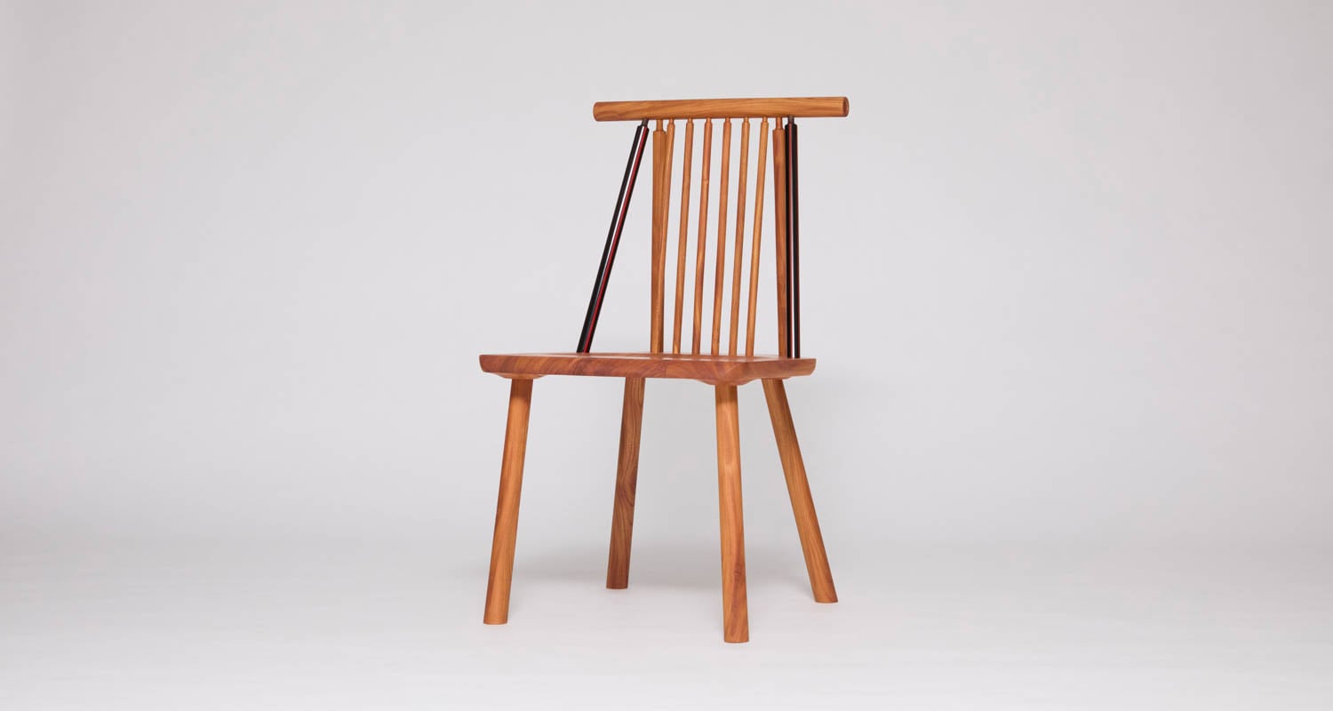 A wooden chair with a flat seat, four angled legs, and a vertical slatted backrest, photographed against a plain white background.