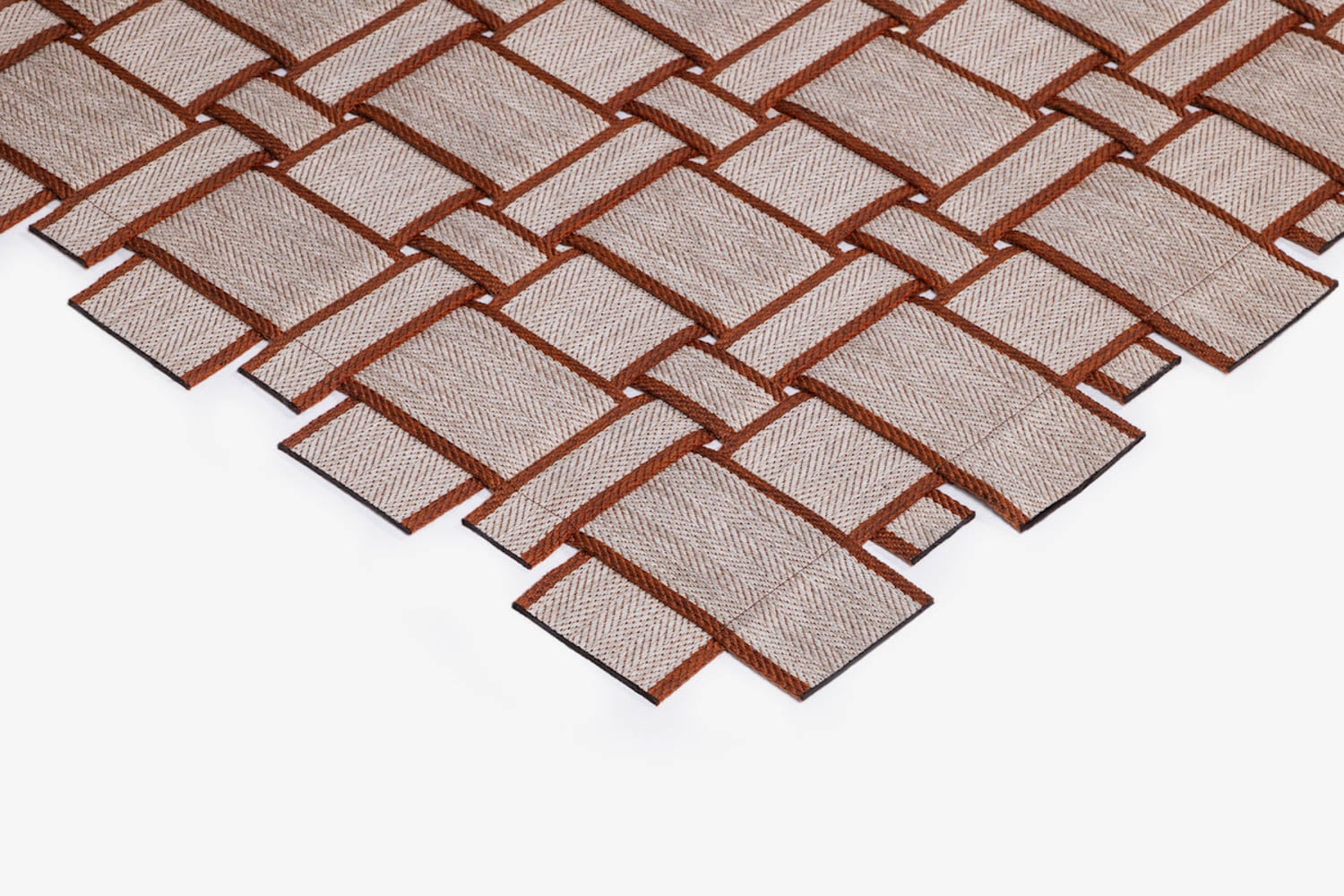 A close-up view of a woven textile pattern with light beige fabric strips interlaced with brown borders, arranged diagonally on a white background.