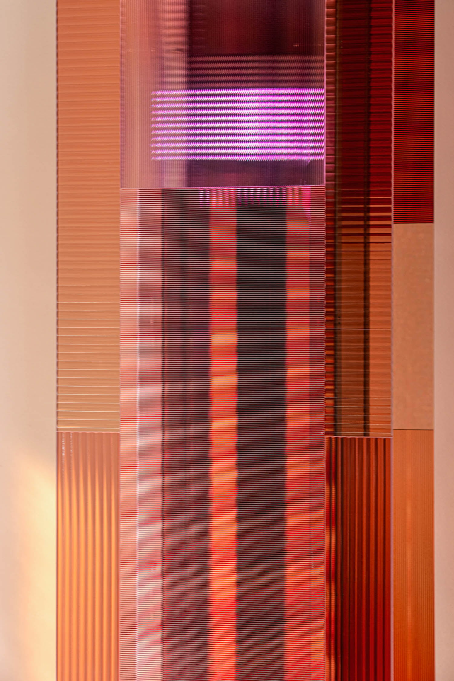 Rectangular panels with horizontal and vertical grooves in shades of red, orange, and purple, with a purple light at the top center.