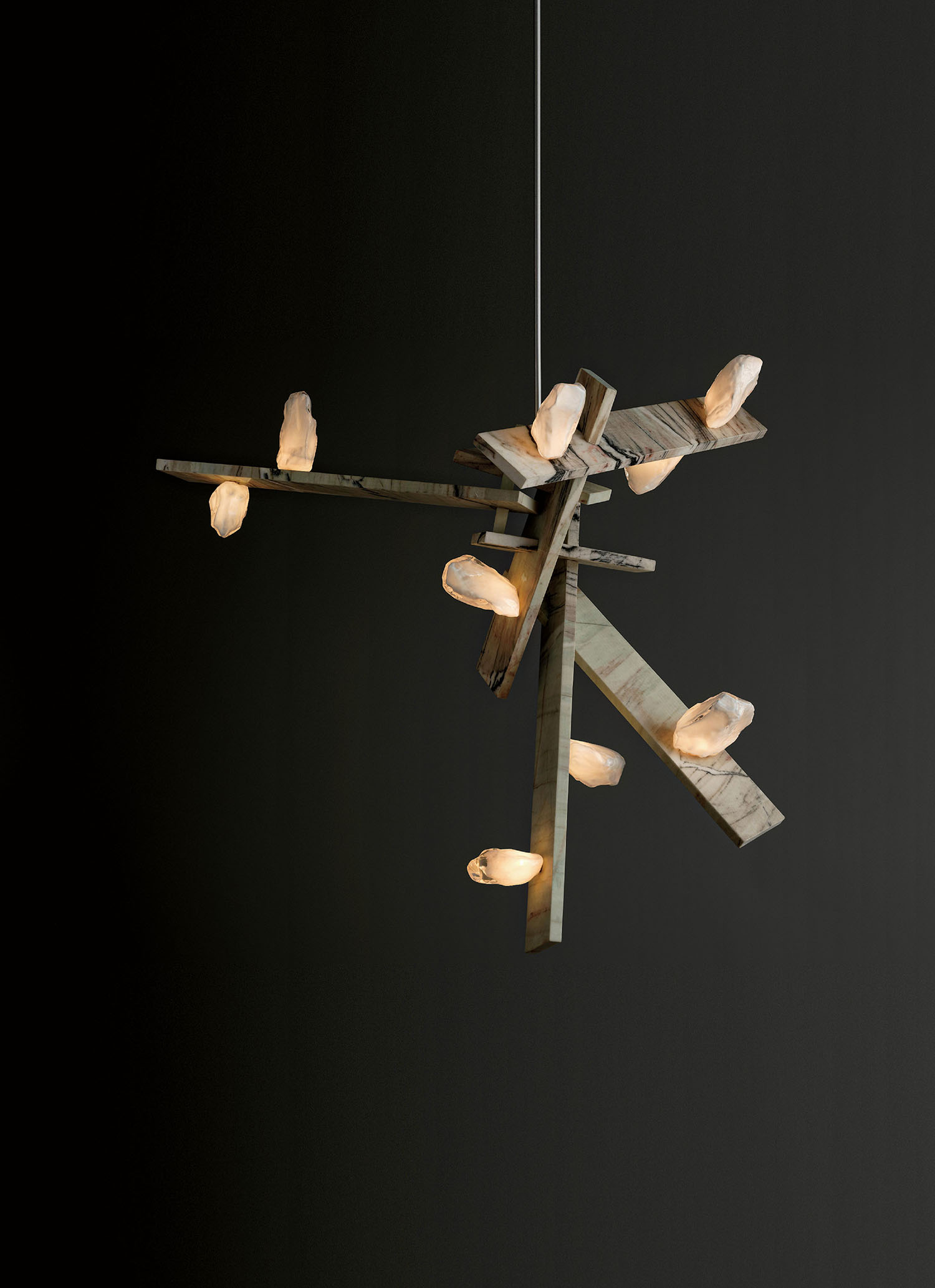 A modern chandelier with intersecting wooden beams and multiple soft glowing lights, suspended against a dark background.