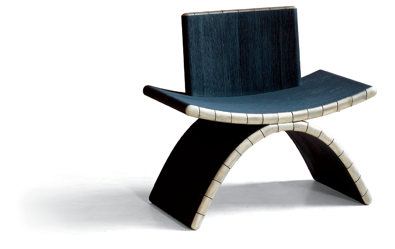 Modern chair with a curved wooden seat and backrest, featuring white segmented edges and an arched black base, displayed on a white background.