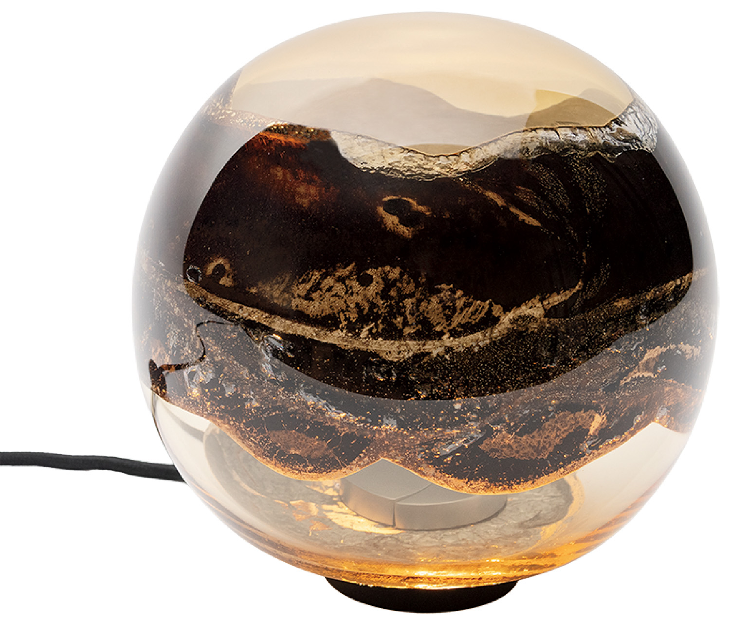 A round glass table lamp with brown and gold swirling patterns inside, resting on a small base with a visible power cord.