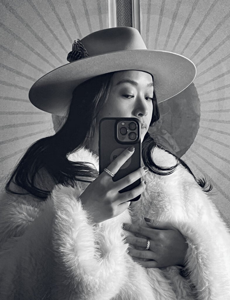 A woman in a hat taking a picture of herself.