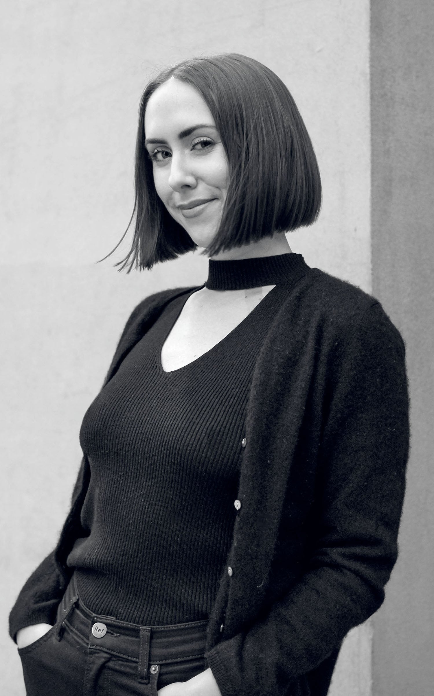 A woman standing in front of a wall.