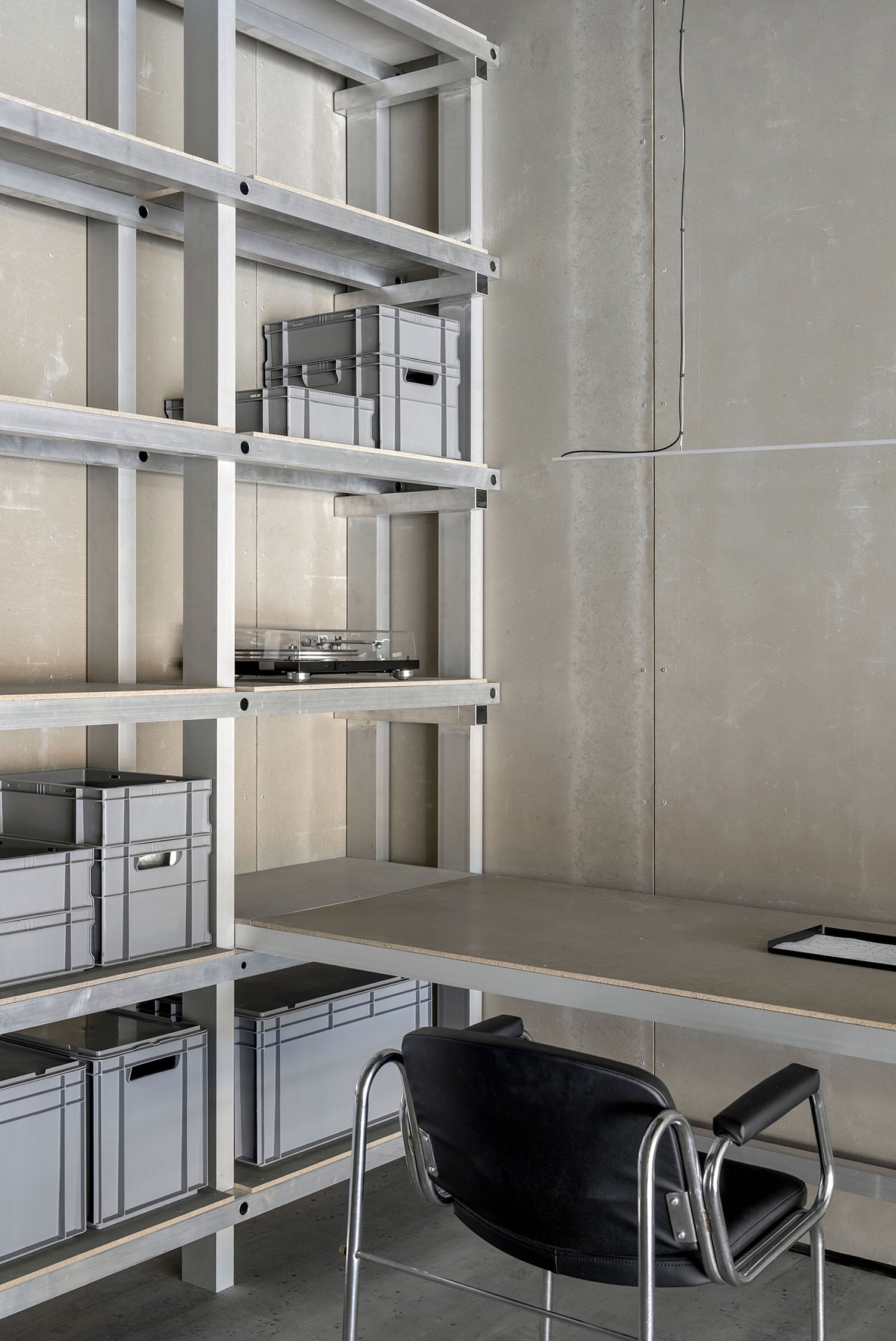 A desk with a chair and a shelf.