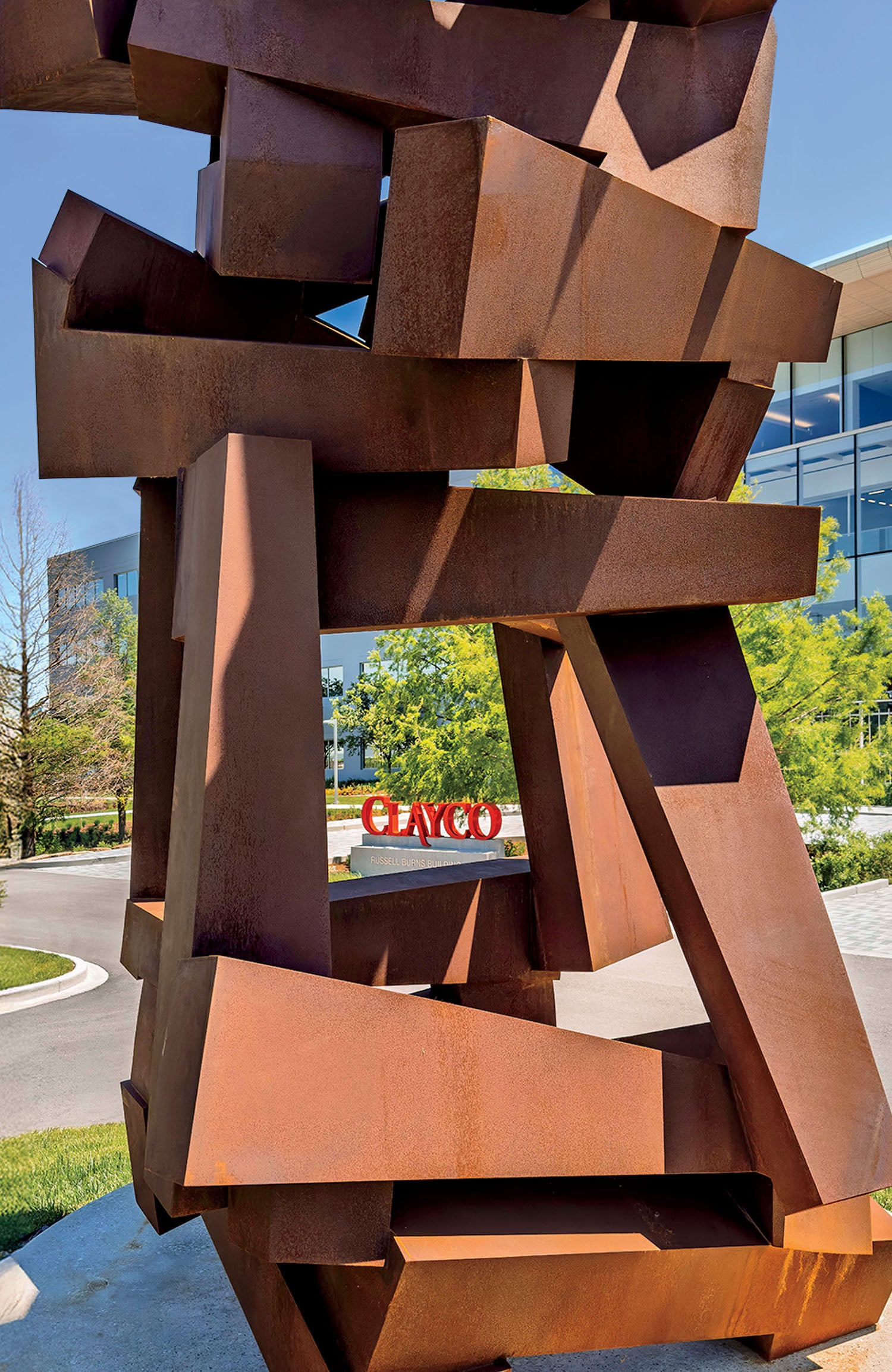 A sculpture in front of a building with a sign.