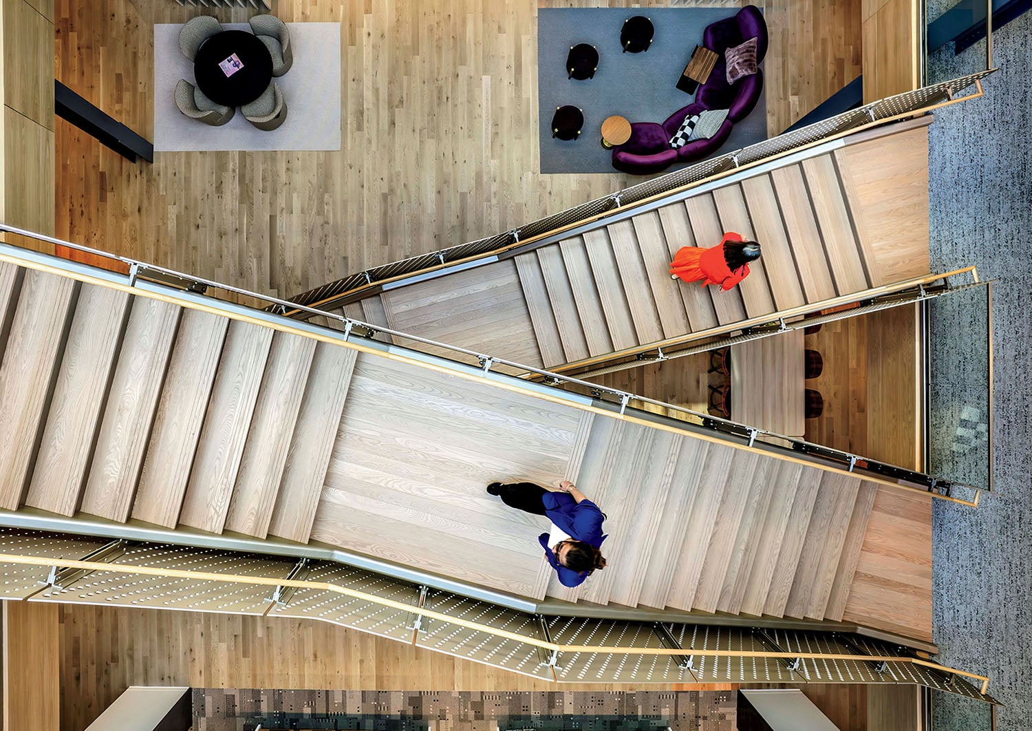 A group of people walking down a wooden staircase.